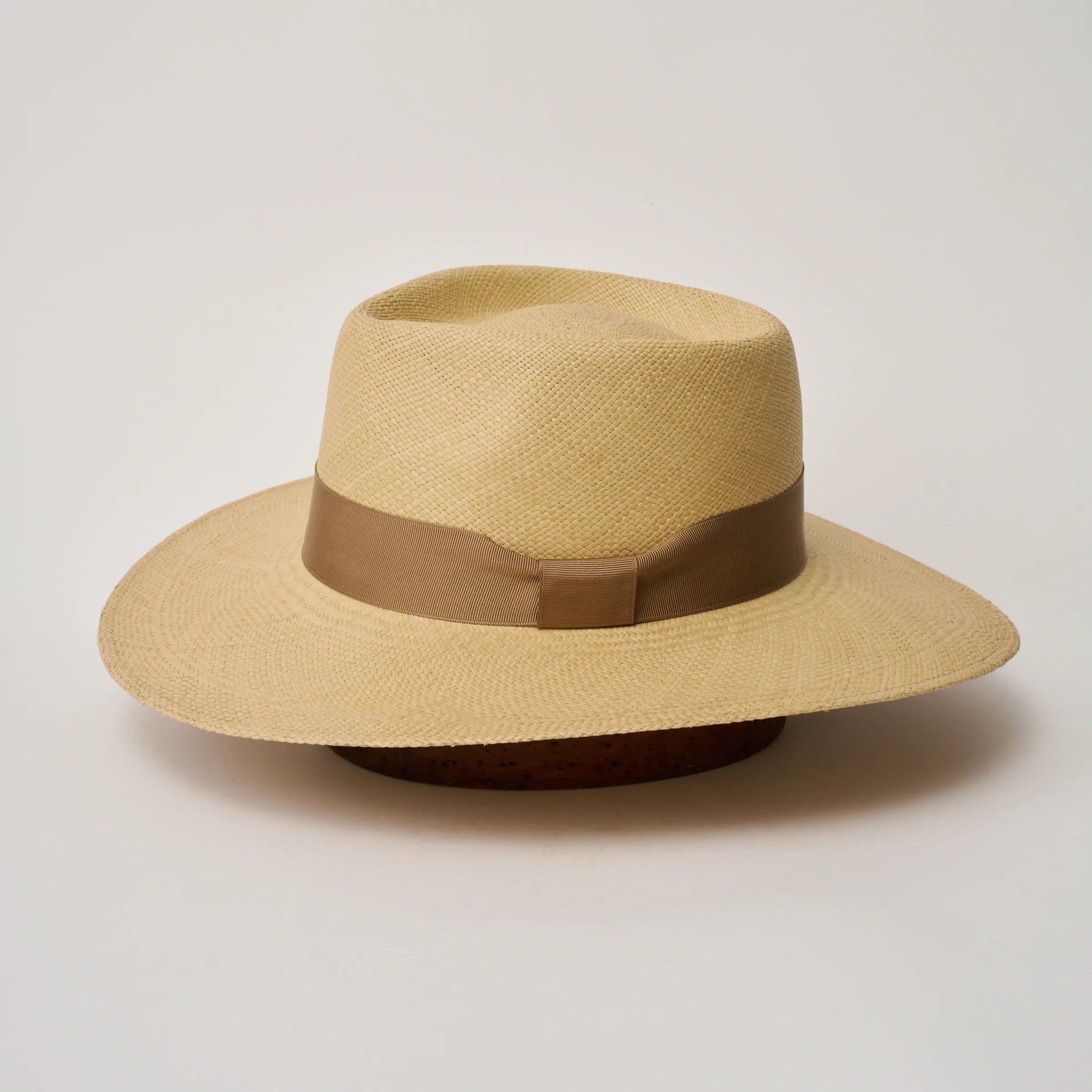 Studio image of the Camilo Country 
Sand coloured Panama Hat with Tan trim shown from the side, showing the brim shape and ribbon finish.