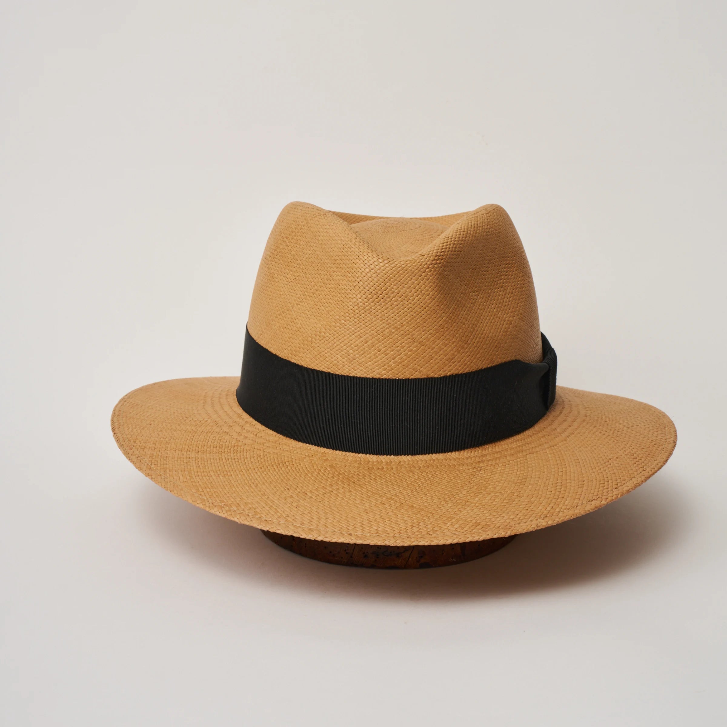 Studio image of the Camilo Executive Fino Toffee coloured Panama Hat with Black trim taken from the front, showing pinch.