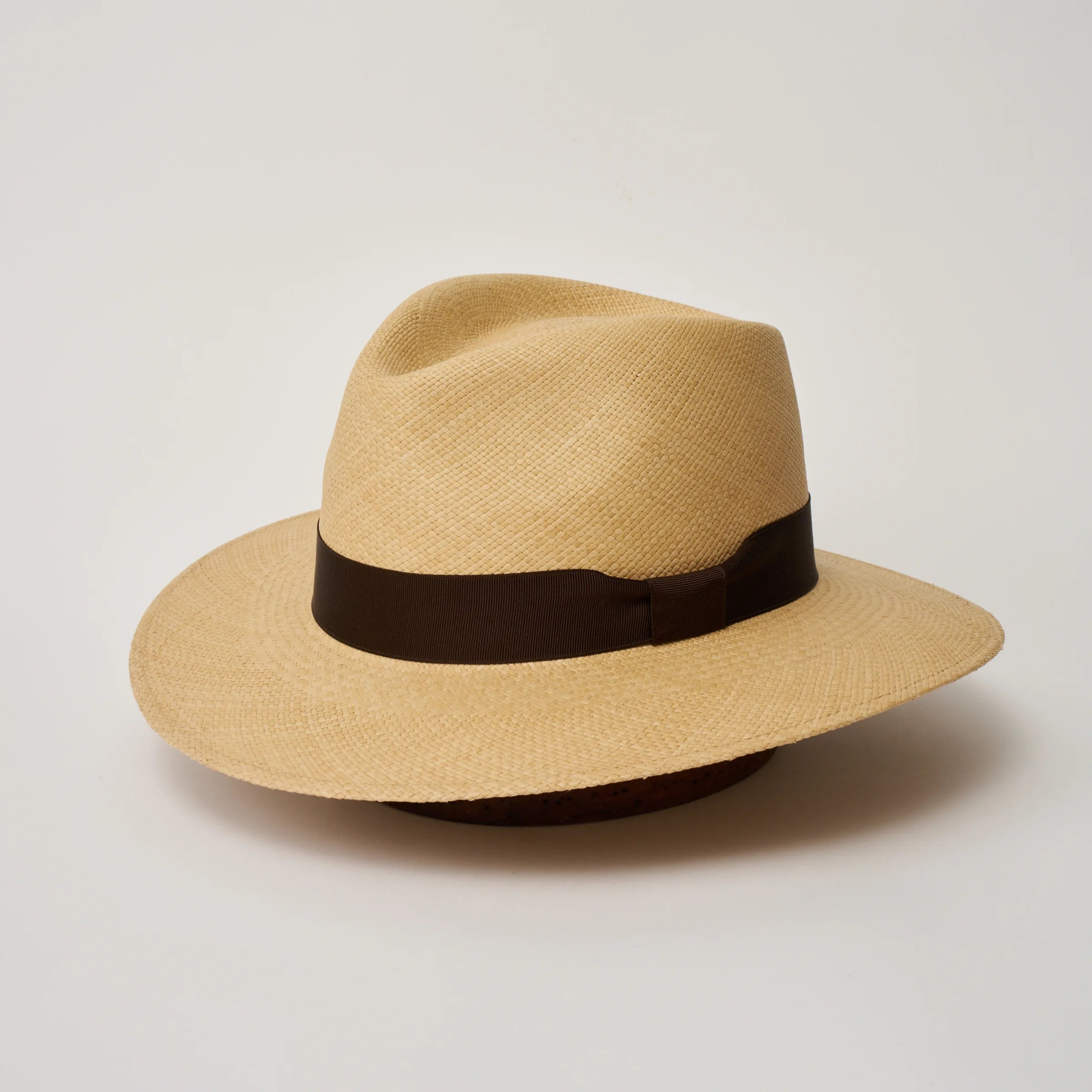 Studio image of the Camilo Executive Sand coloured Panama Hat with Caffe trim, angled showing the crown shape, front crease and ribbon details.