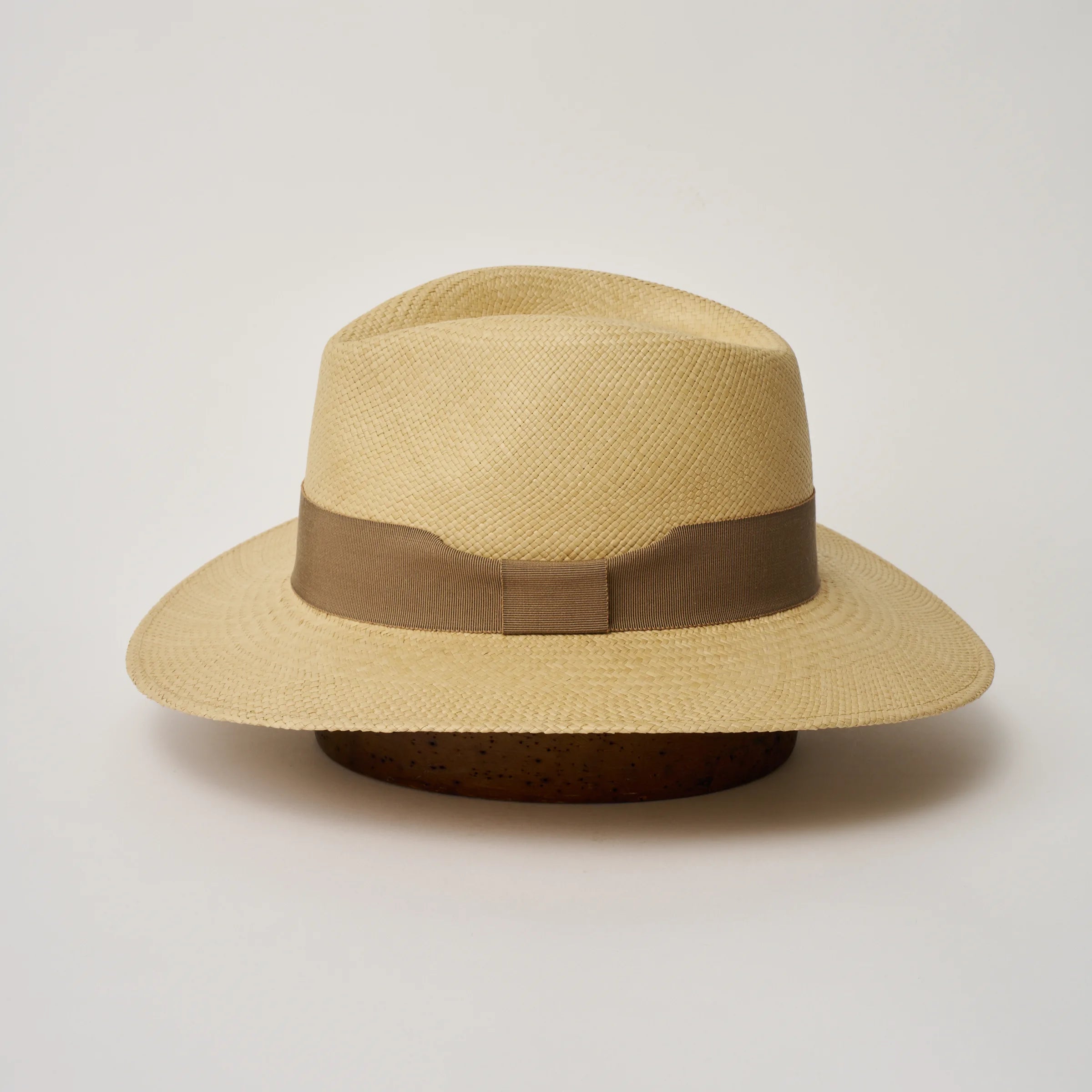 Studio image of the Camilo Executive 
Sand coloured Panama Hat with Oat trim shown from the side, showing the brim shape and ribbon finish.