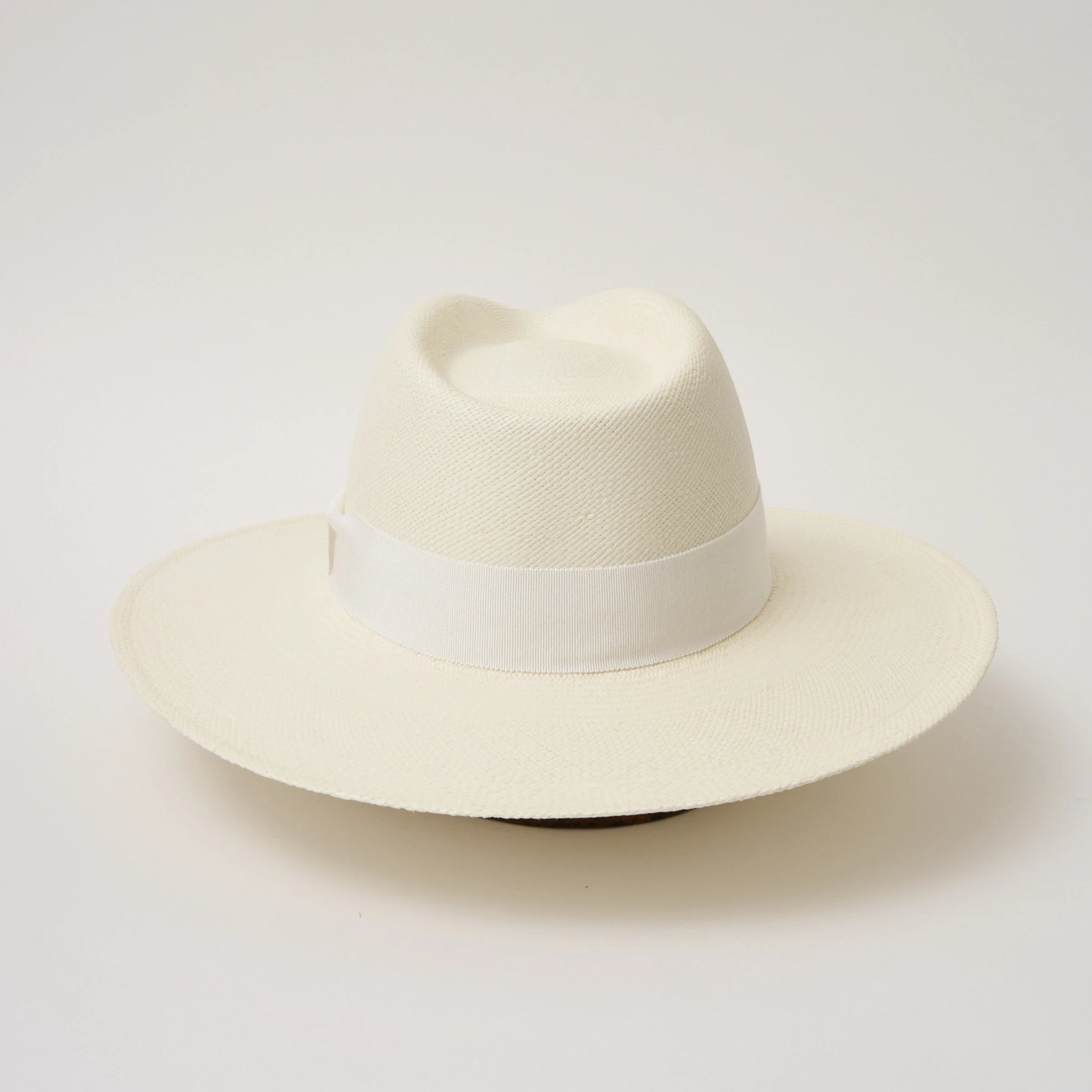 Studio image of the Camilo Oro Cream coloured Panama Hat with White trim shown from the back.