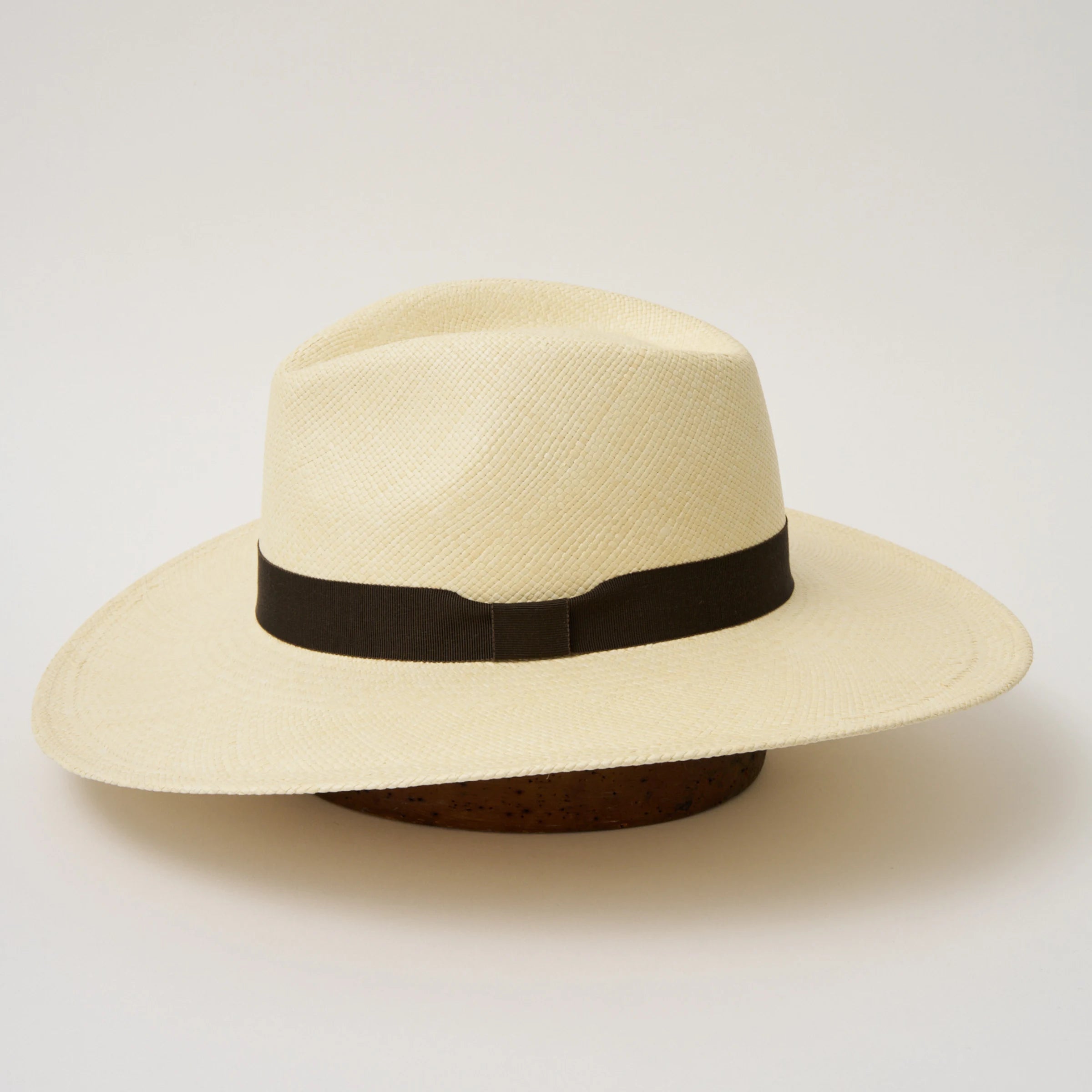 Studio image of the Camilo Oro Natural coloured Panama Hat with Espresso trim taken from the side, showing brim and ribbon finish.