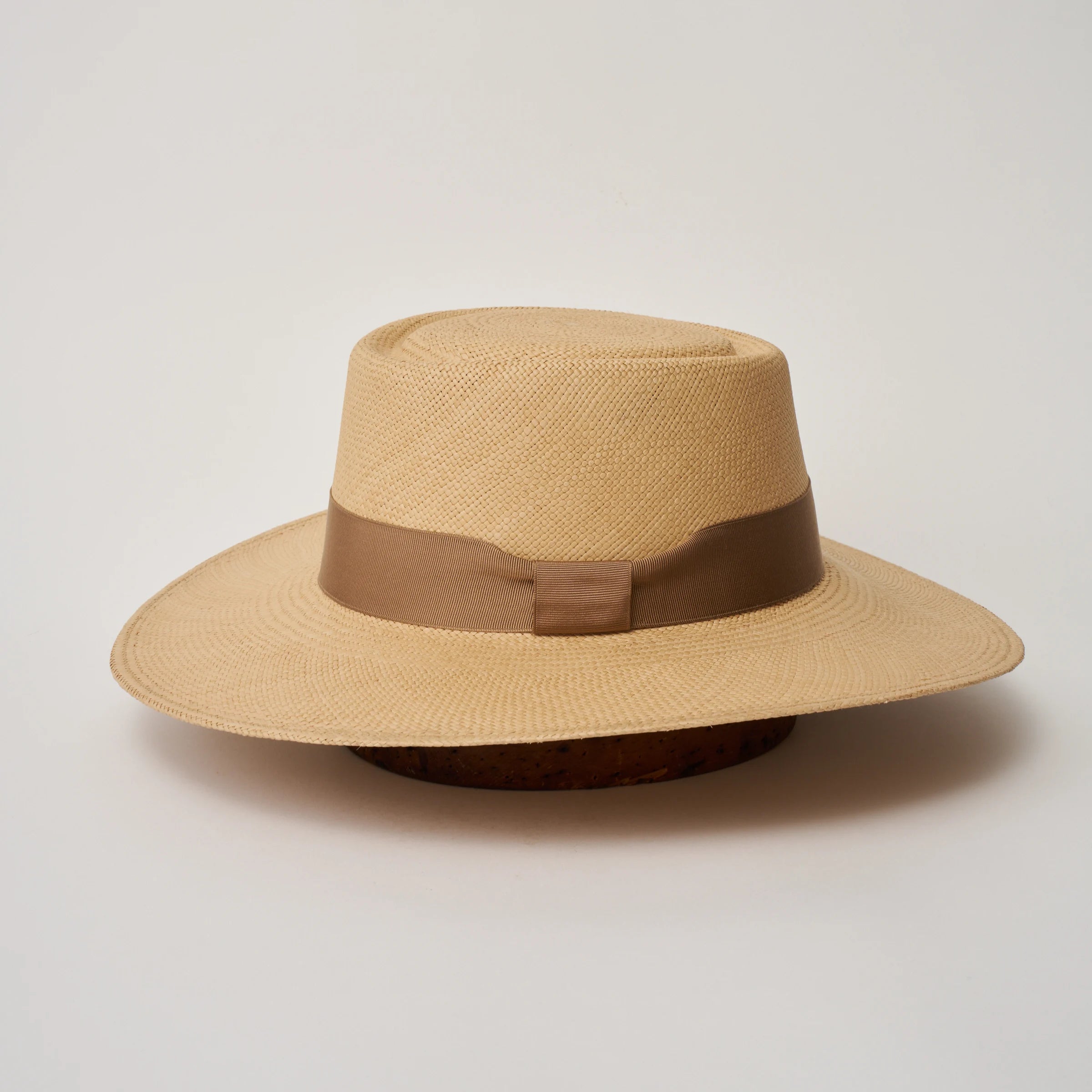Studio image of the Camilo Sol
Natural coloured Panama Hat with Oat trim shown from the side, showing the brim shape and ribbon finish.
