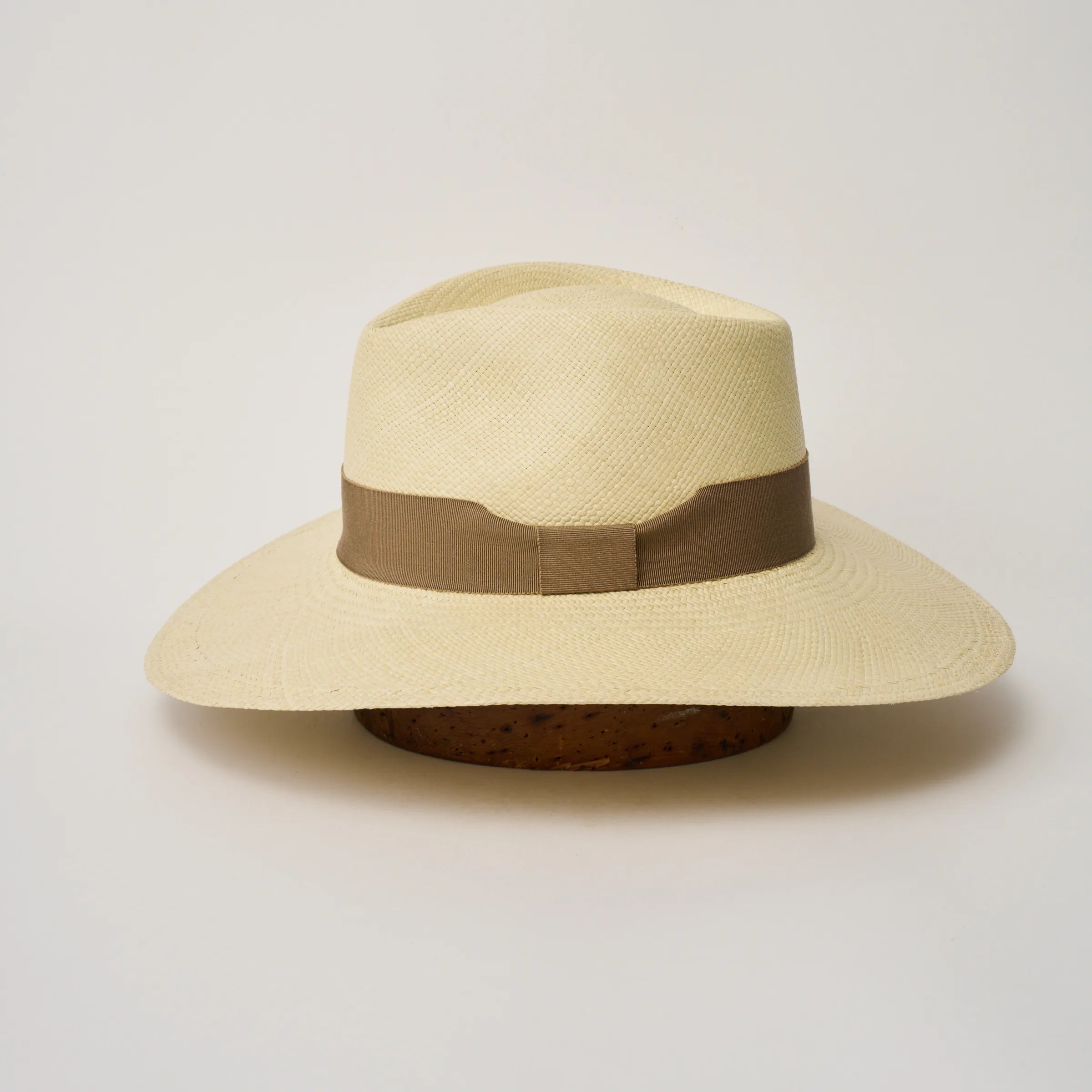 Studio image of the Camilo Vita Natural coloured Panama Hat with Oat trim taken from the side, showing brim and ribbon finish.