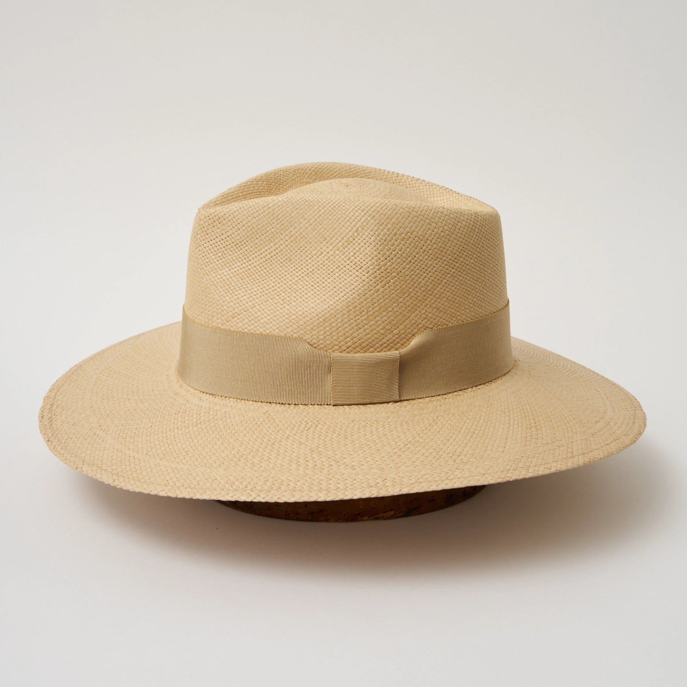 Studio image of the Camilo Vita Sand coloured Panama Hat with Camel trim taken from the side, showing brim and ribbon finish.