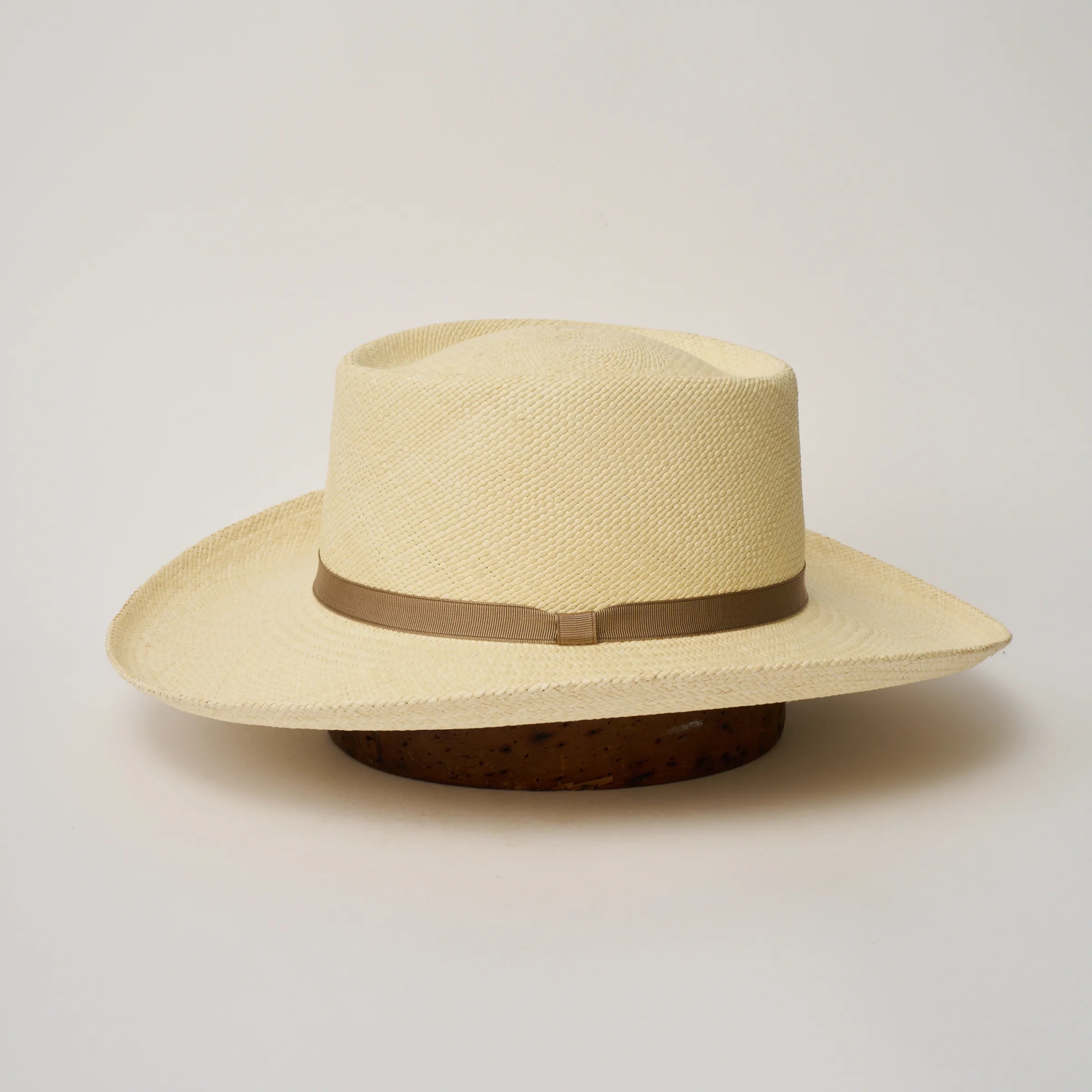 Studio image of the Camilo Gambler
Natural coloured Panama Hat with Taupe trim shown from the side, showing the brim shape and ribbon finish.