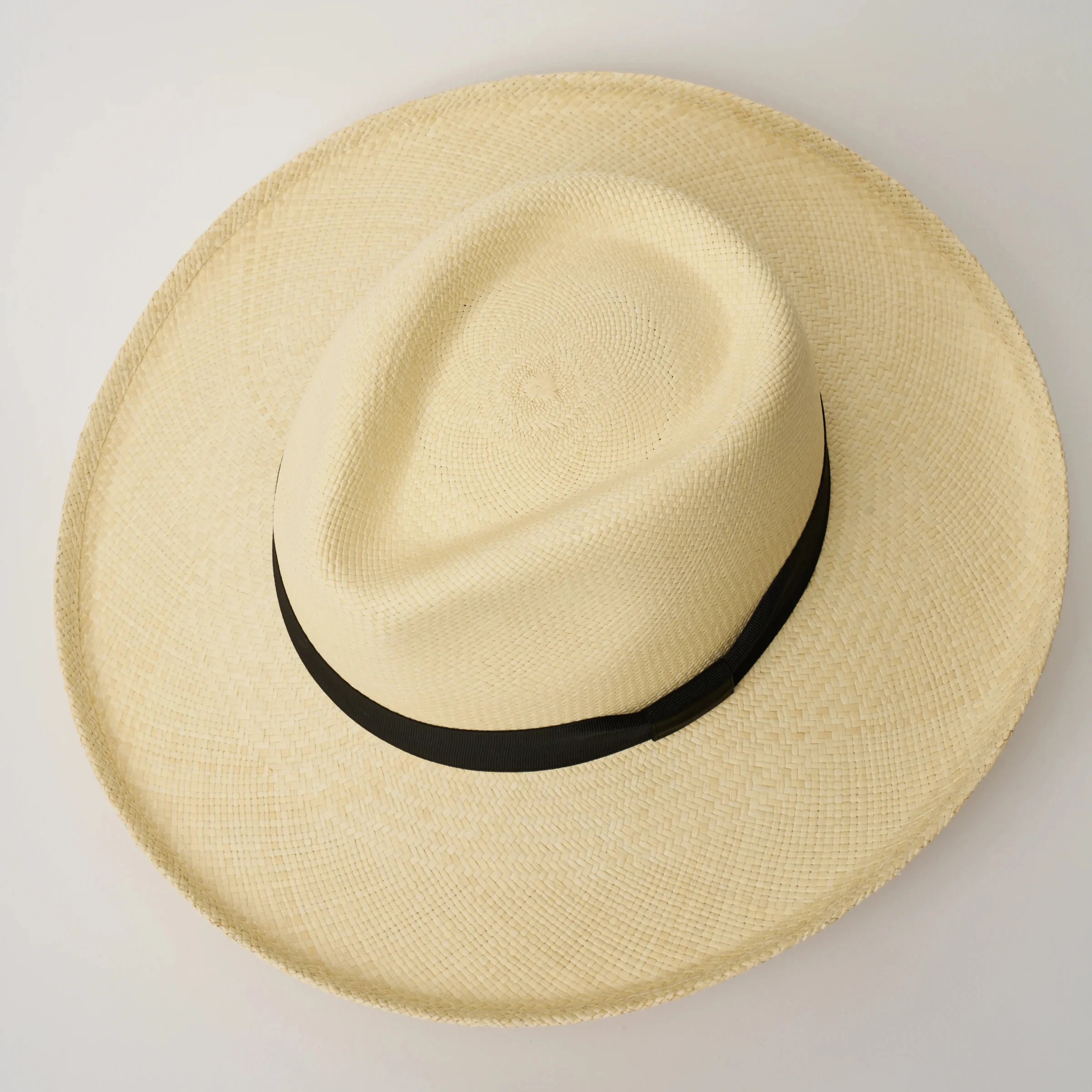 Studio image, looking top-down on the Camilo Grand Planter Natural coloured Panama Hat with Black trim, showing the crown shape.