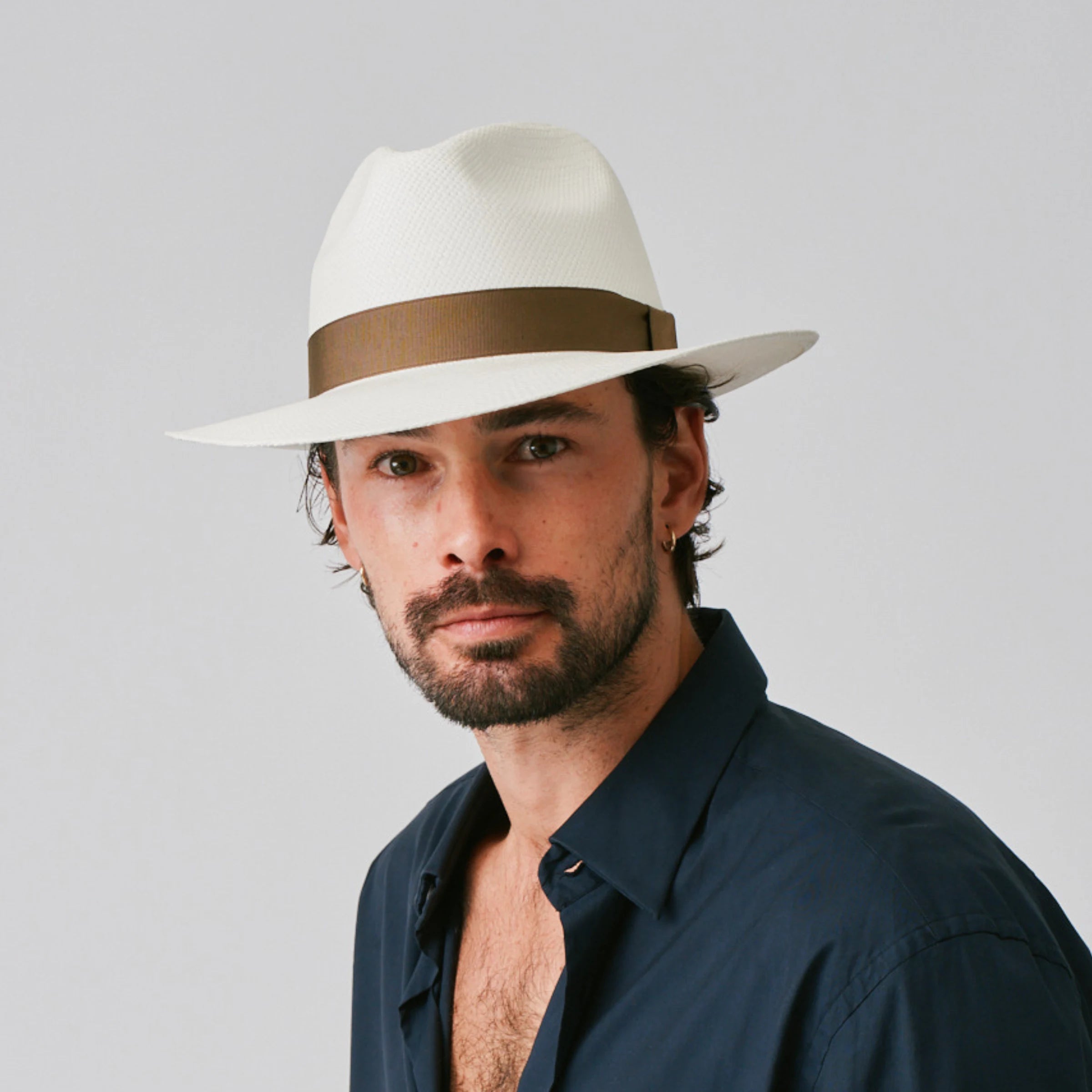 Man wearing a Camilo Classic Cream / Fawn Panama hat and navy shirt against a plain background.