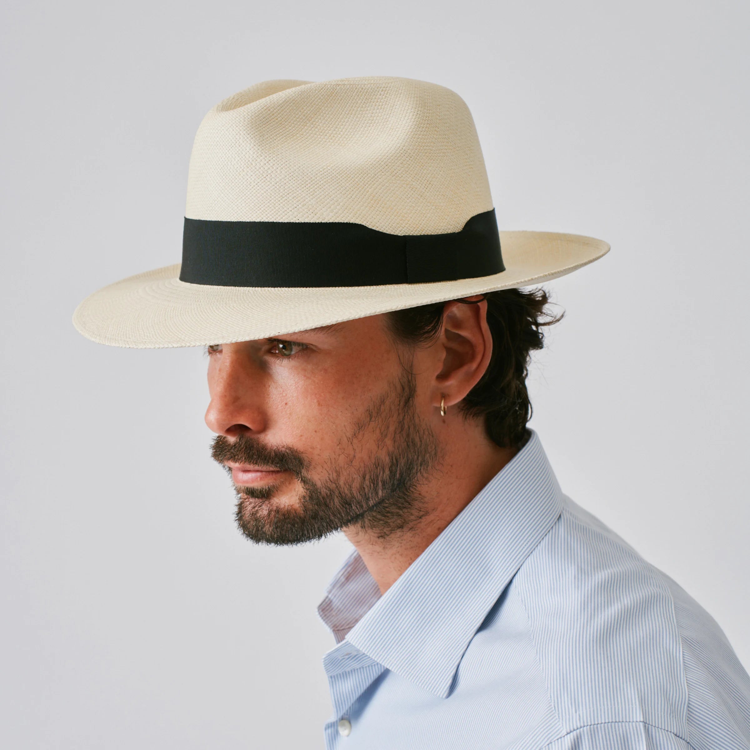 Man wearing a Camilo Classic Fino Natural / Black Panama hat against a plain background.