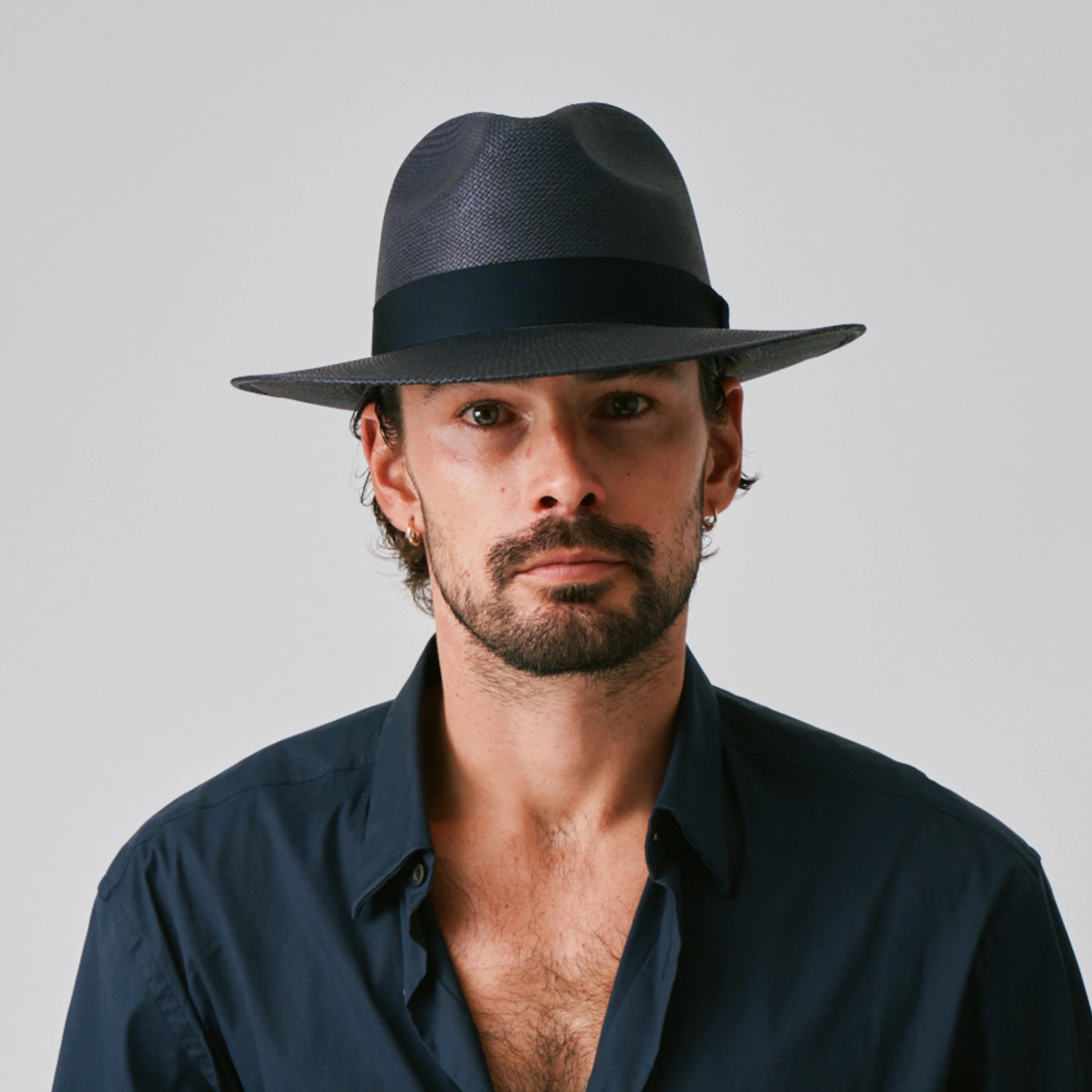 Man wearing a Camilo Classic Navy / Marine Panama hat and navy shirt against a plain background.