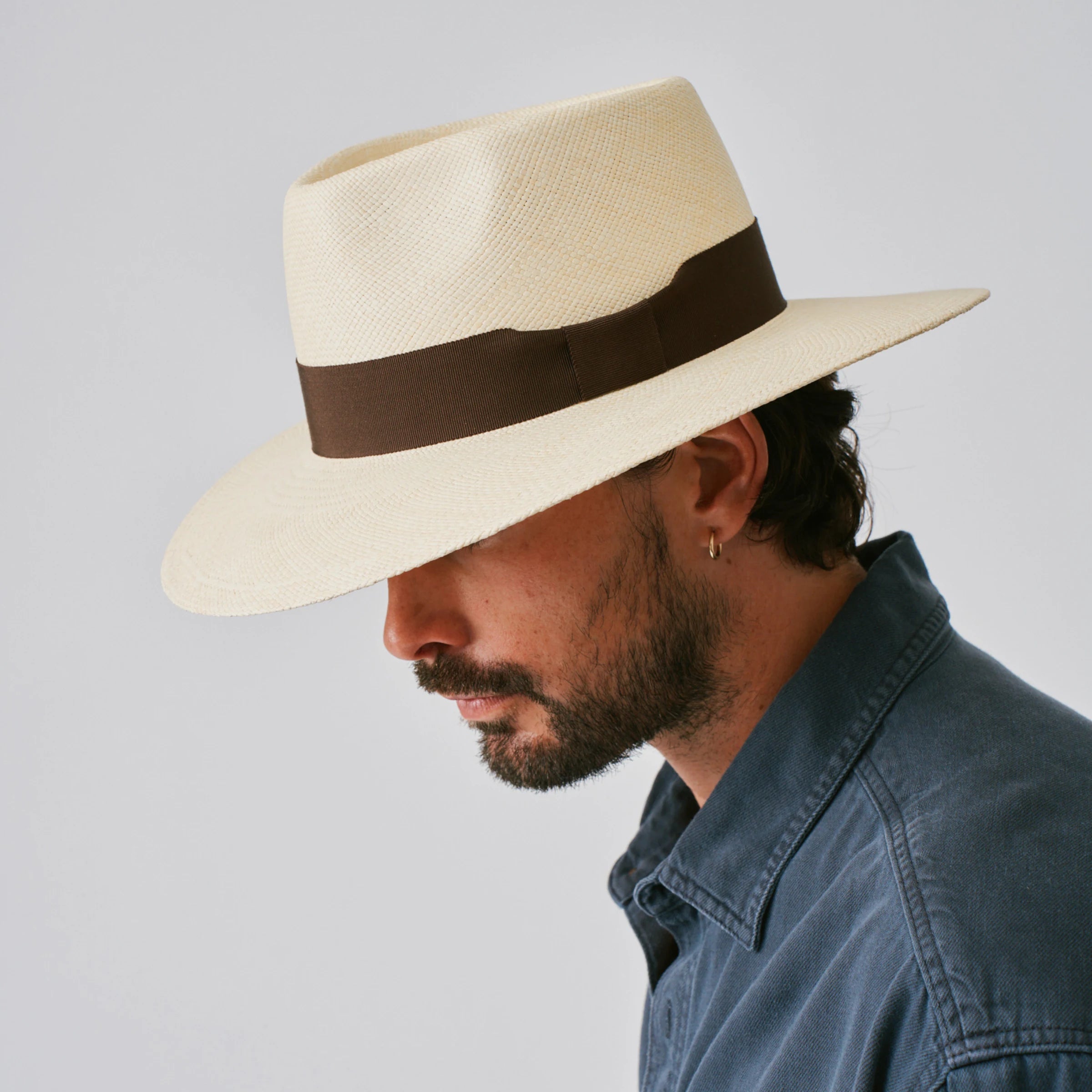 Man wearing a Country Natural / Chocolate Panama hat against a plain background.