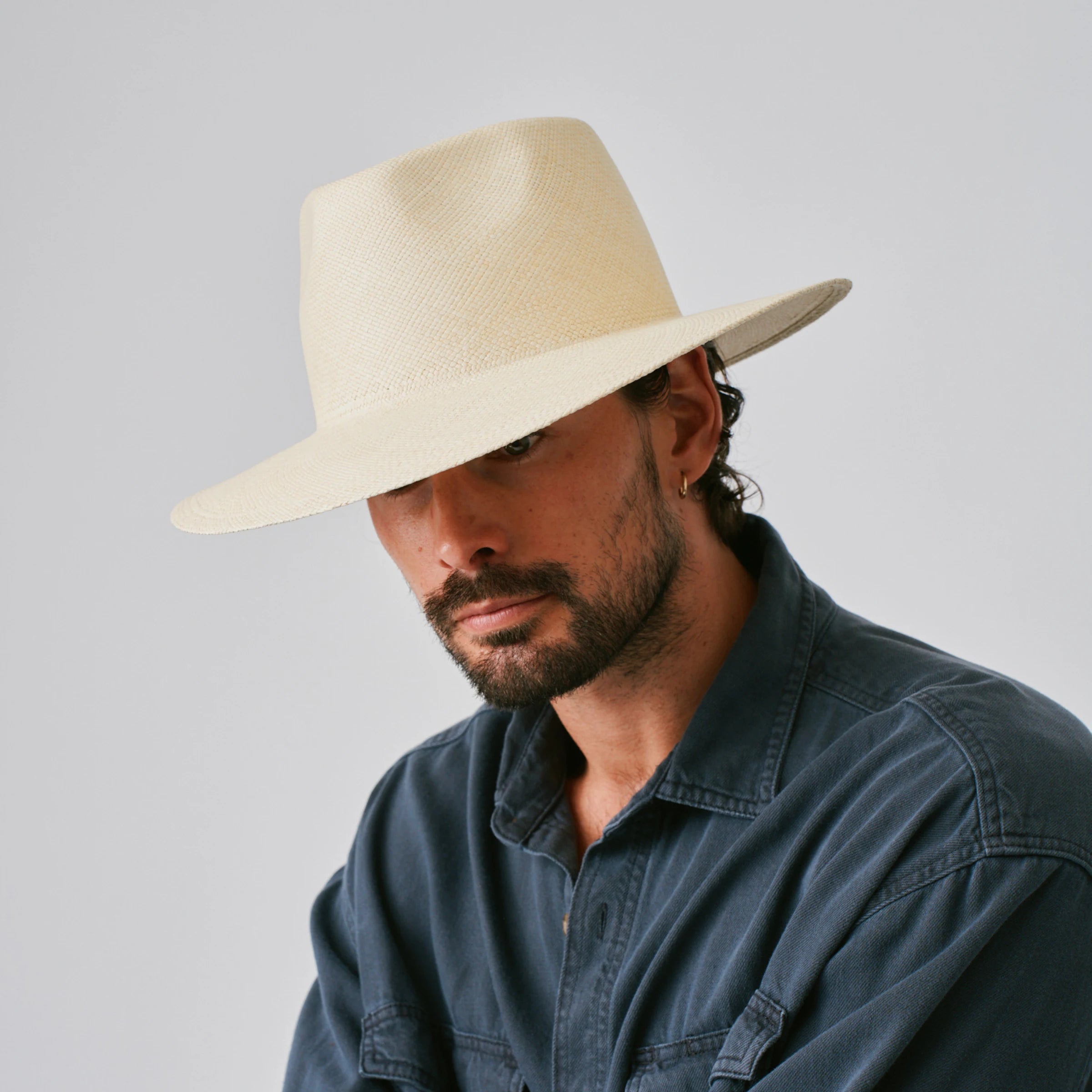 Man wearing a Country Natural Panama hat against a plain background.