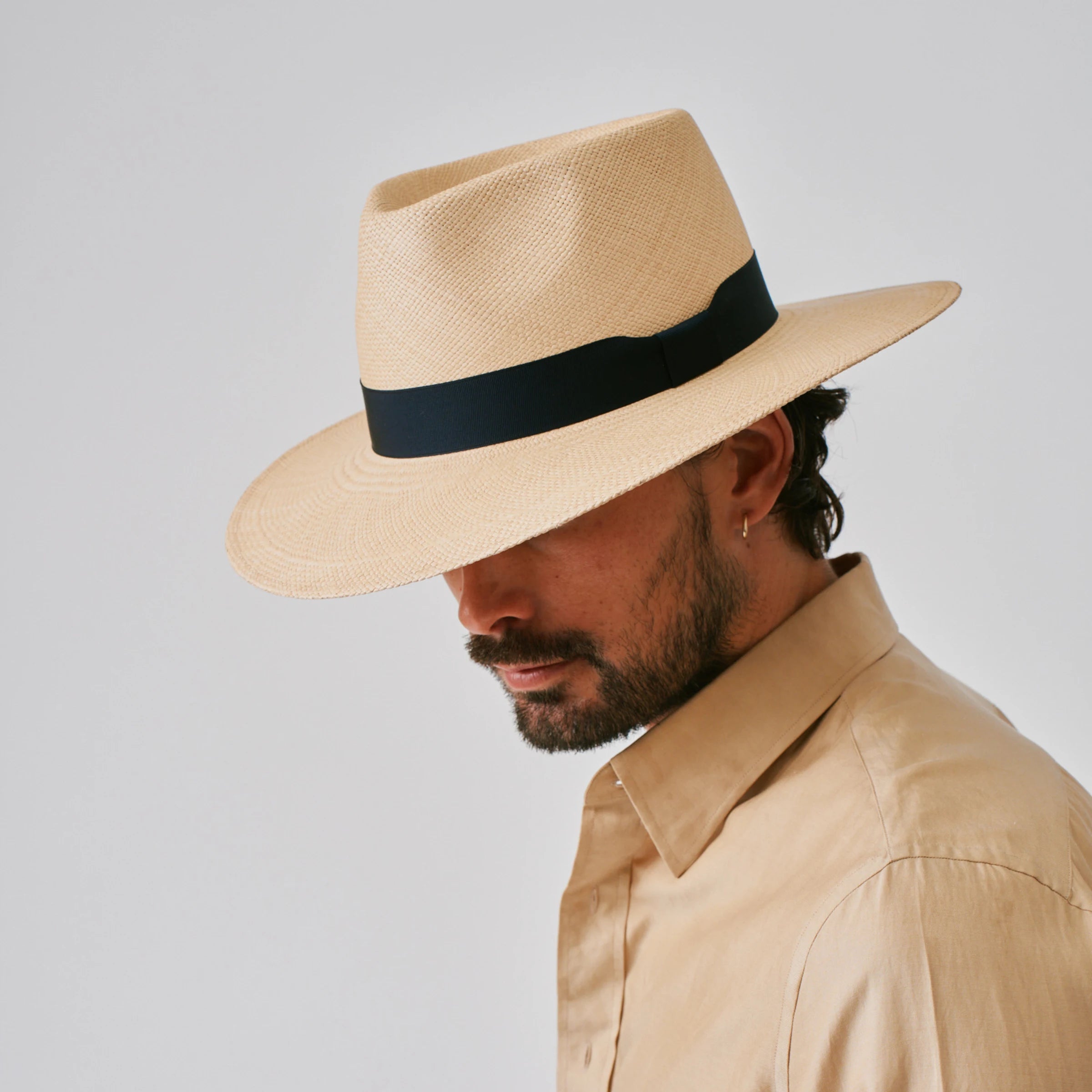 Man wearing a Country Sand / Marine Panama hat against a plain background.