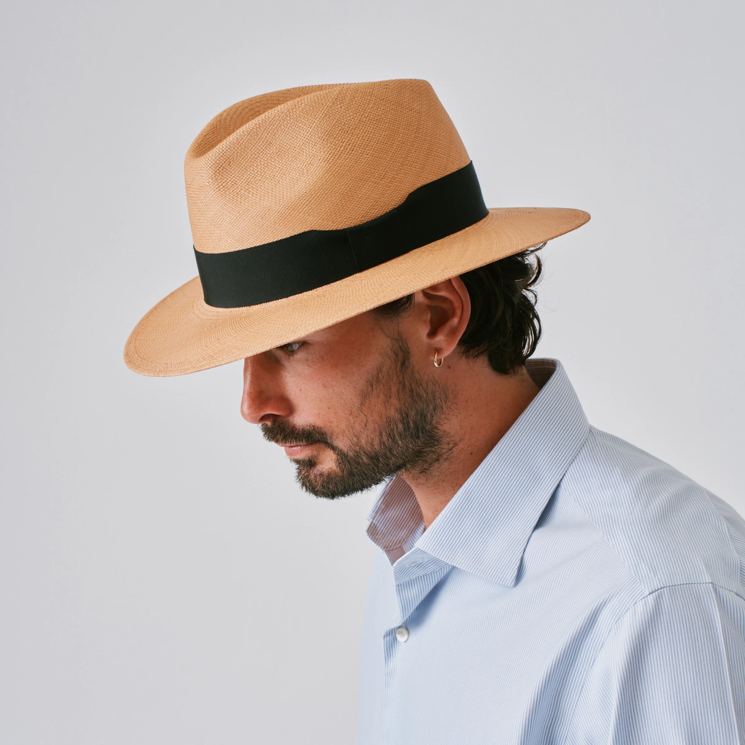 Man wearing a Executive Fino Toffee / Black Panama hat against a plain background.
