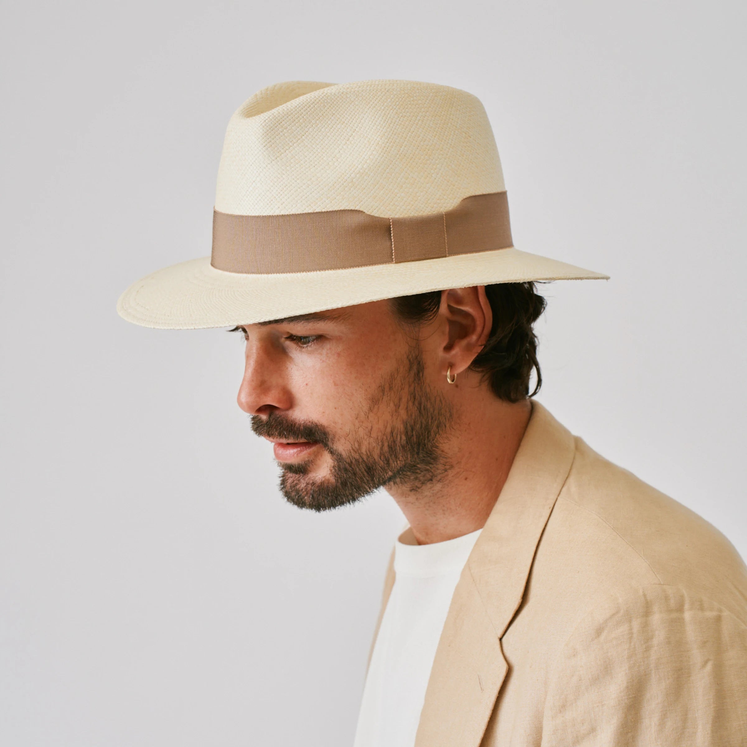 Man wearing a Executive Natural / Oat Panama hat against a plain background.