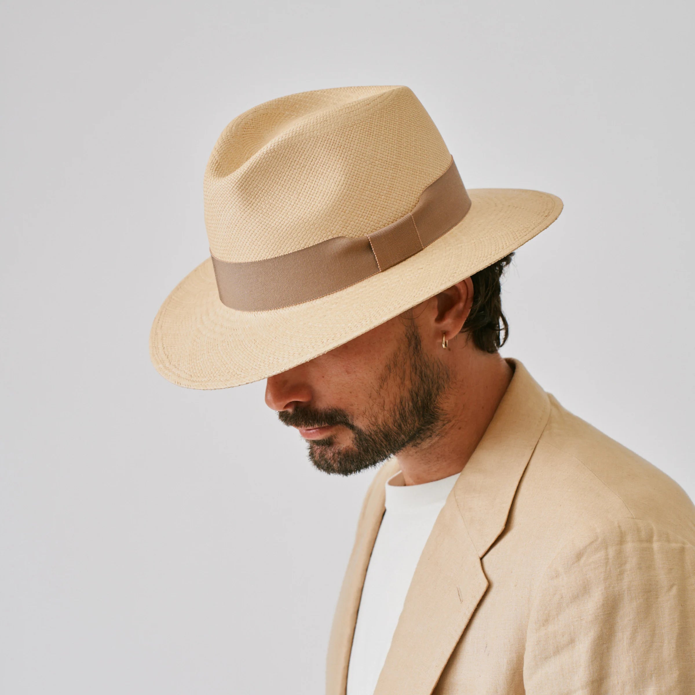 Man wearing a Executive Sand / Oat Panama hat against a plain background.