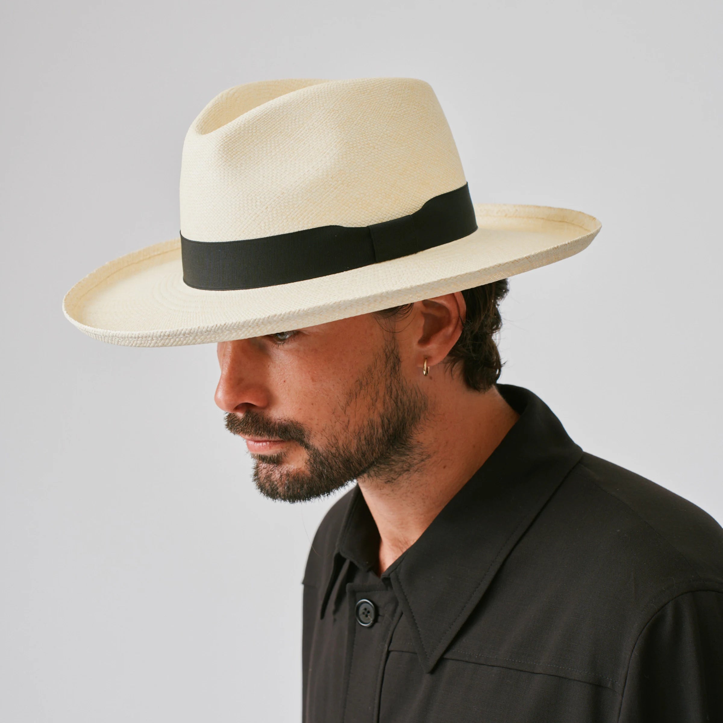 Man wearing a Grand Planter Natural / Black Panama hat against a plain background.