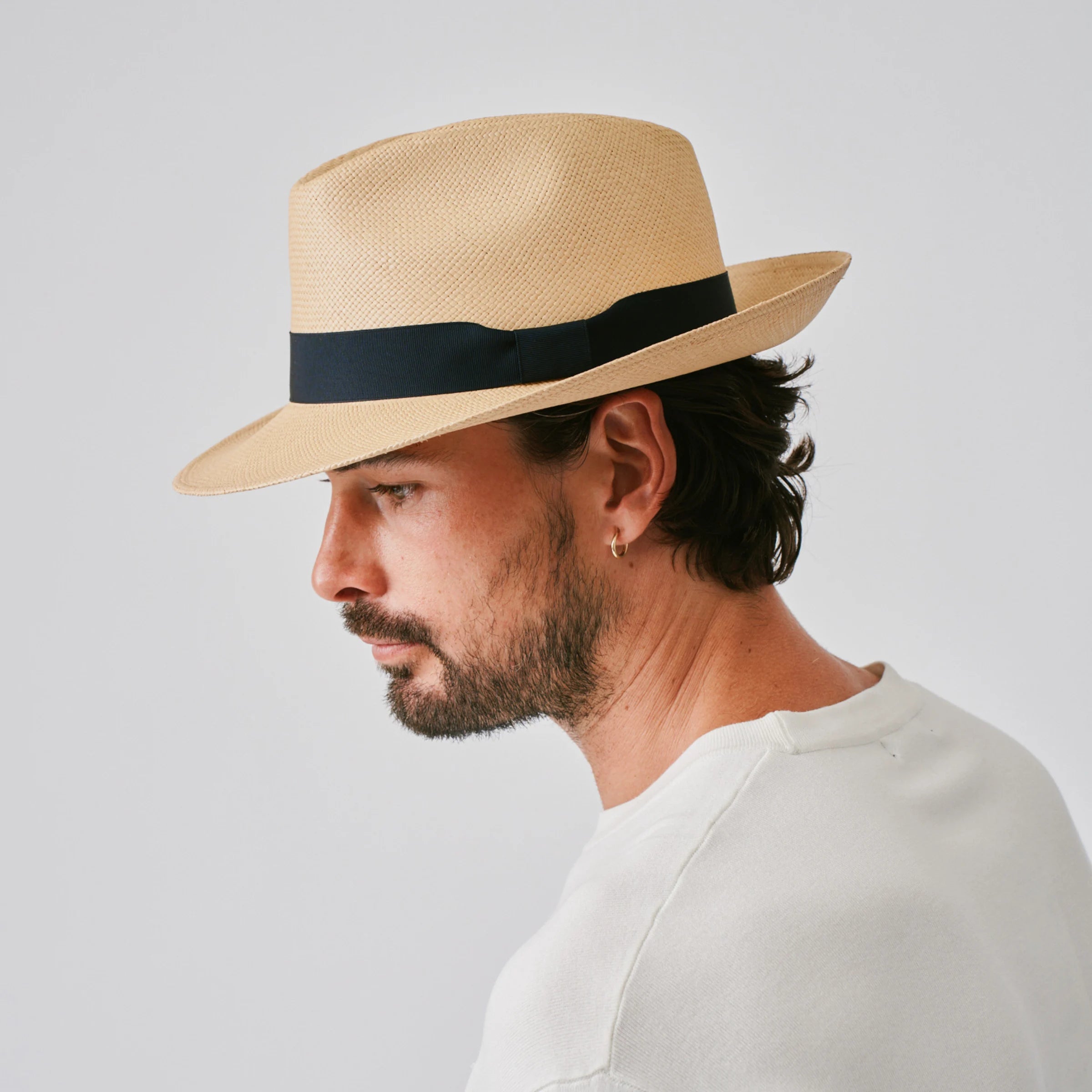 Man wearing a New Fedora Sand / Marine Panama hat against a plain background.