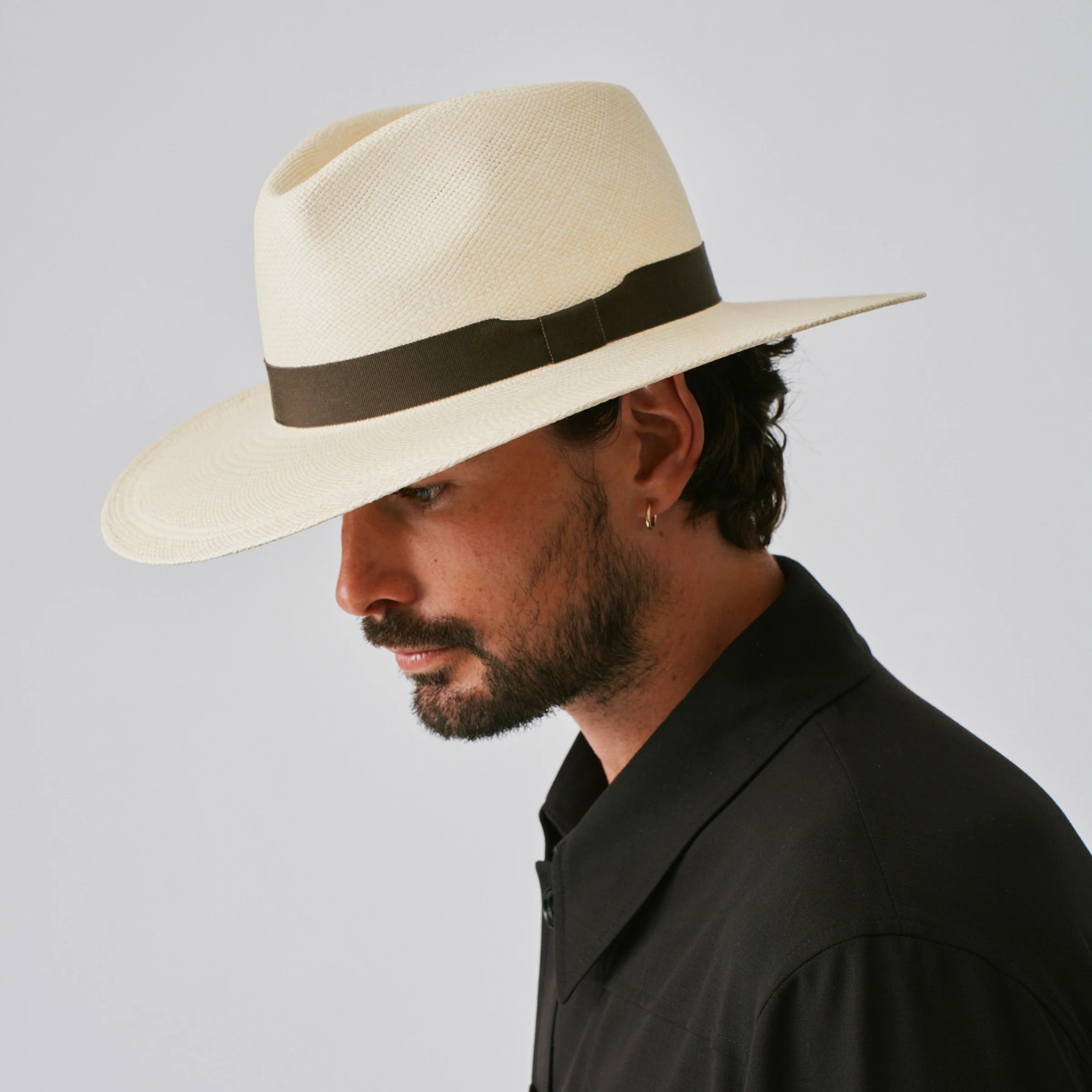 Man wearing a Oro Natural / Espresso Panama hat against a plain background.