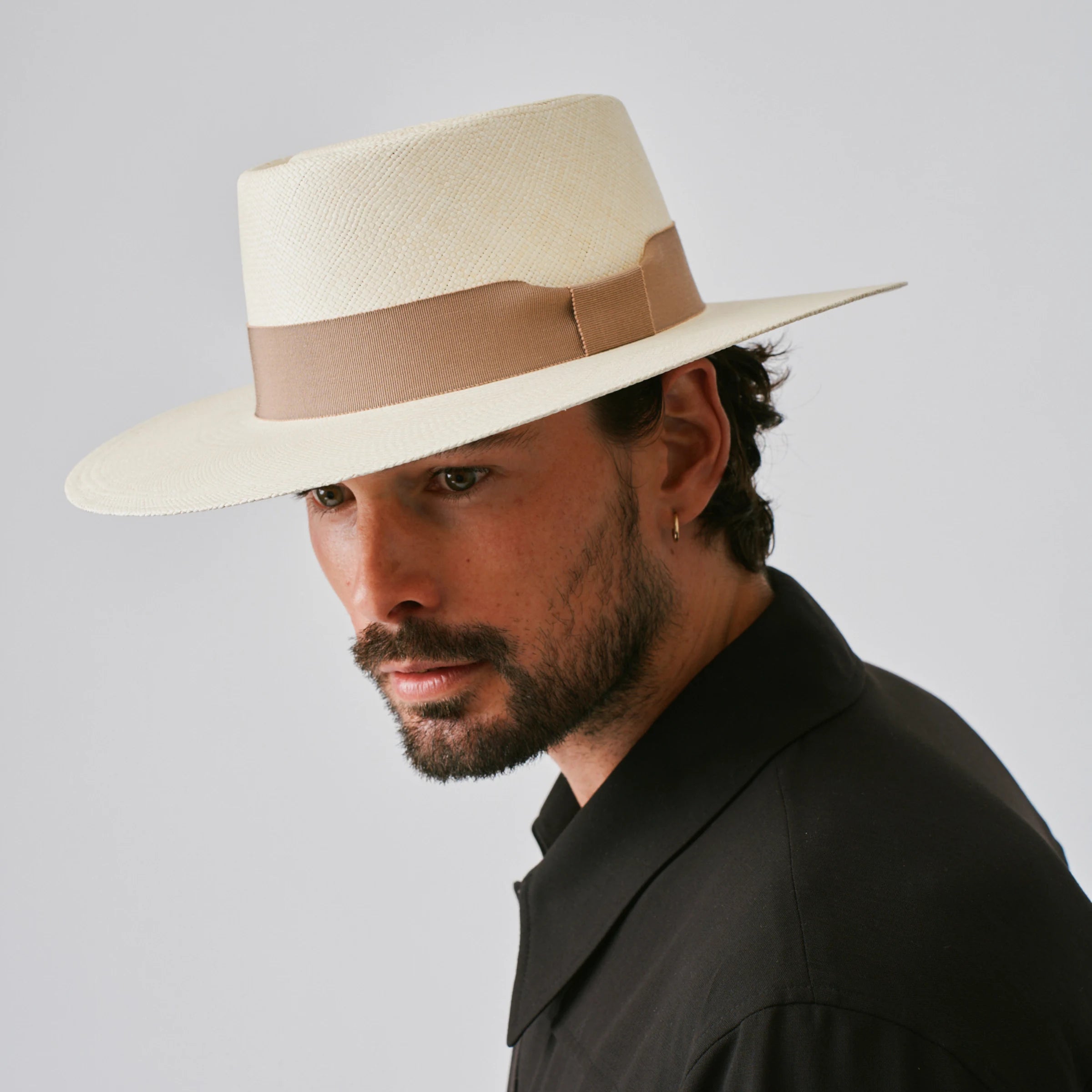 Man wearing a Sol Natural / Oat Panama hat against a plain background