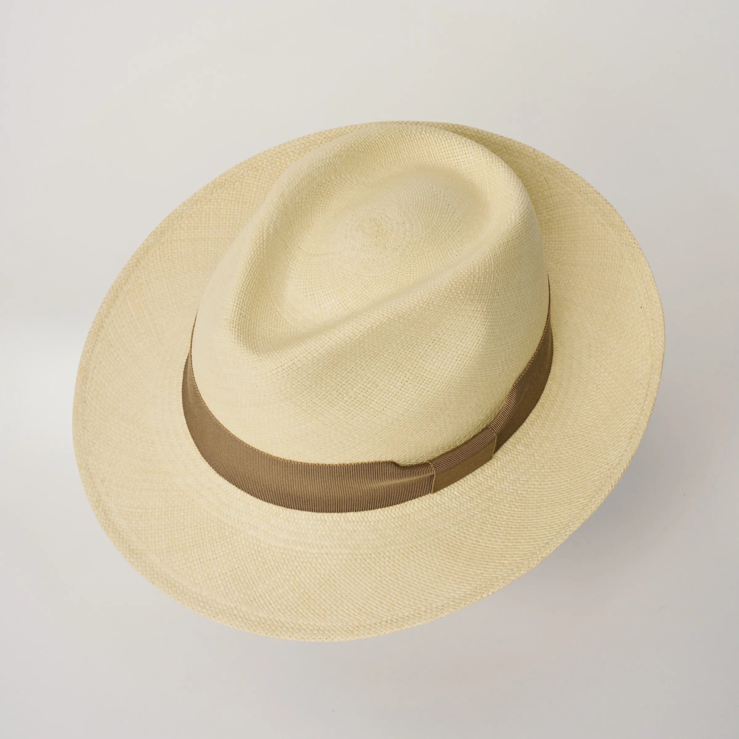 Studio image looking top-down, of the Camilo New Fedora Fino Natural coloured Panama Hat with Oat trim, showing the crown shape and weave details.