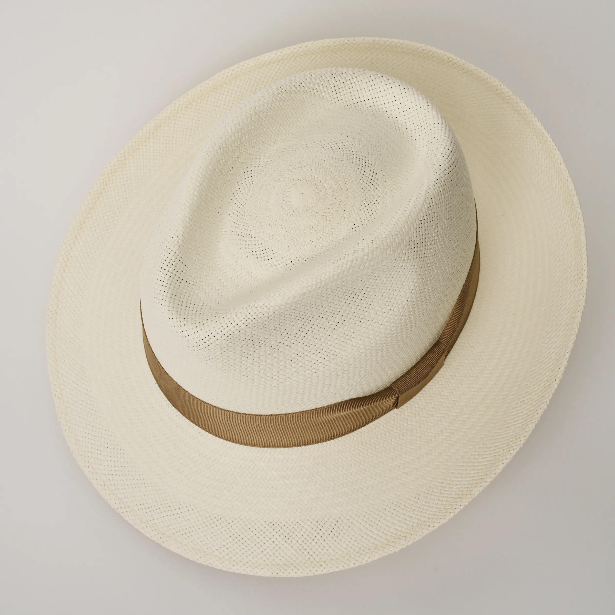 Studio image looking top-down, of the Camilo New Fedora Cream coloured Panama Hat with Tan trim, showing the crown shape and weave details.