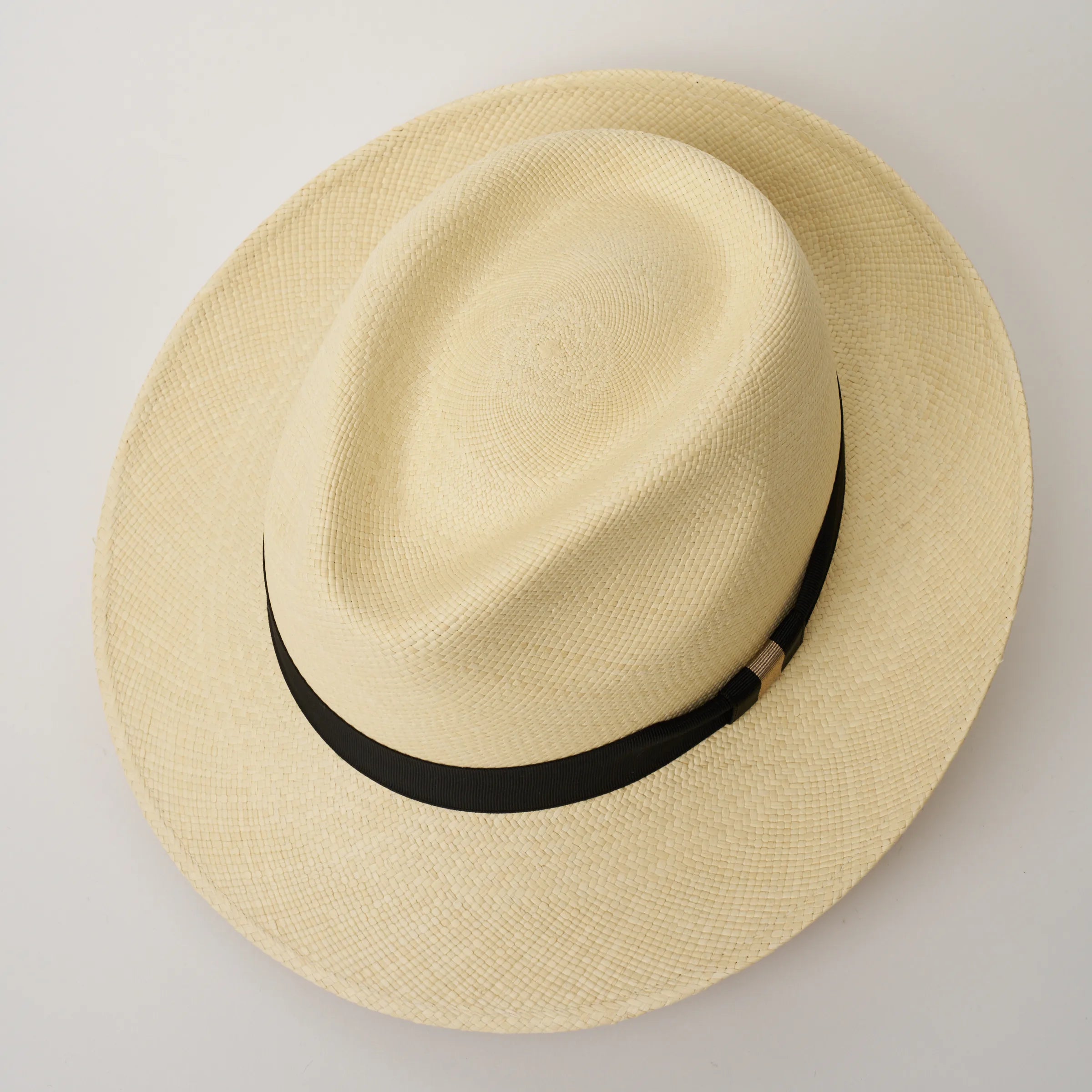 Studio image looking top-down, of the Camilo New Fedora Natural coloured Panama Hat with Black trim, showing the crown shape and weave details.