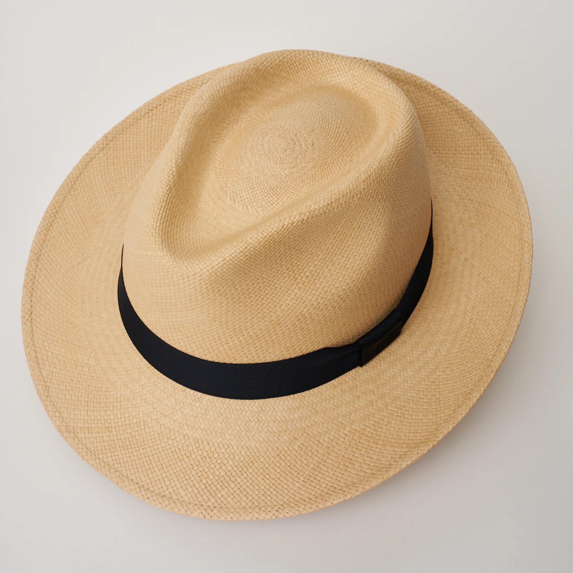 Studio image looking top-down, of the Camilo New Fedora Sand coloured Panama Hat with Marine trim, showing the crown shape and weave details.