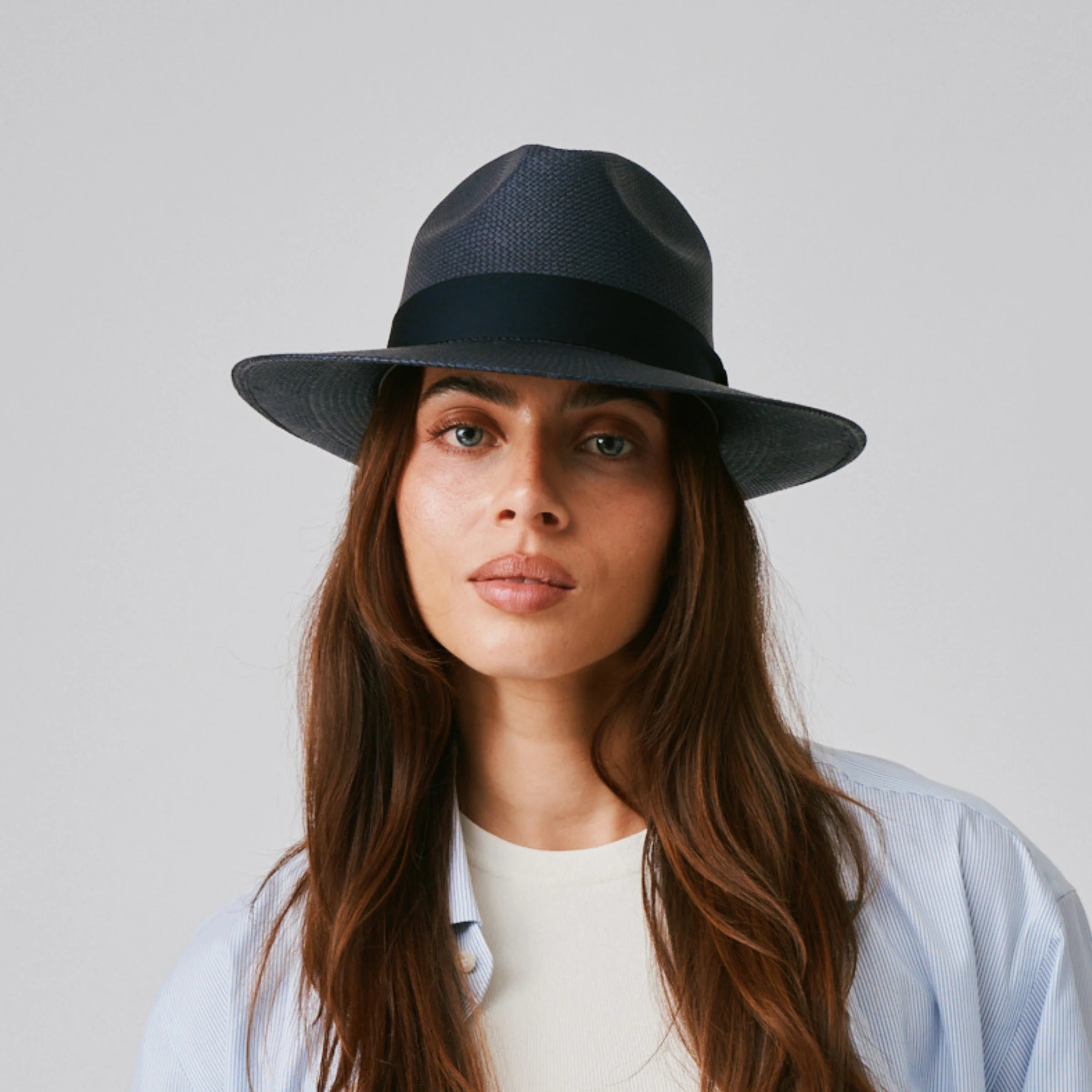 Woman wearing a Camilo Classic Navy / Marine Panama hat and blue shirt against a plain background.