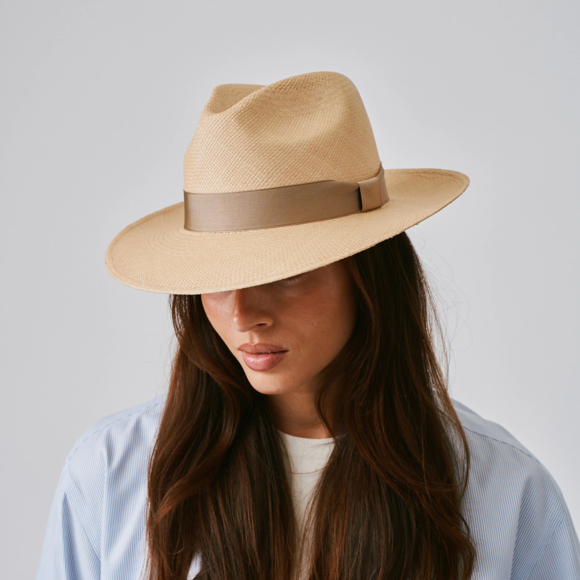 Woman wearing a Camilo Classic Sand / Taupe Panama hat against a plain background.