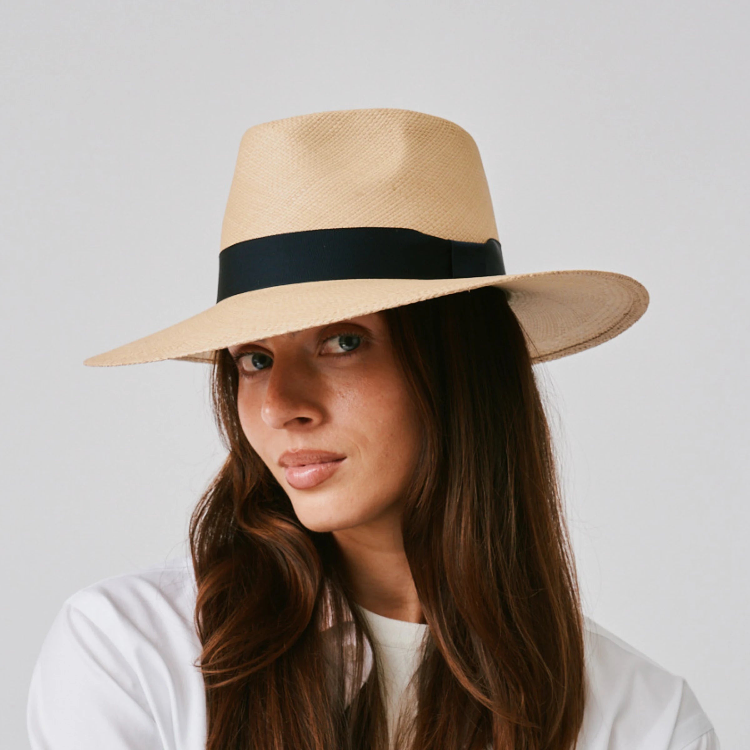 Woman wearing a Country Sand / Marine Panama hat against a plain background.