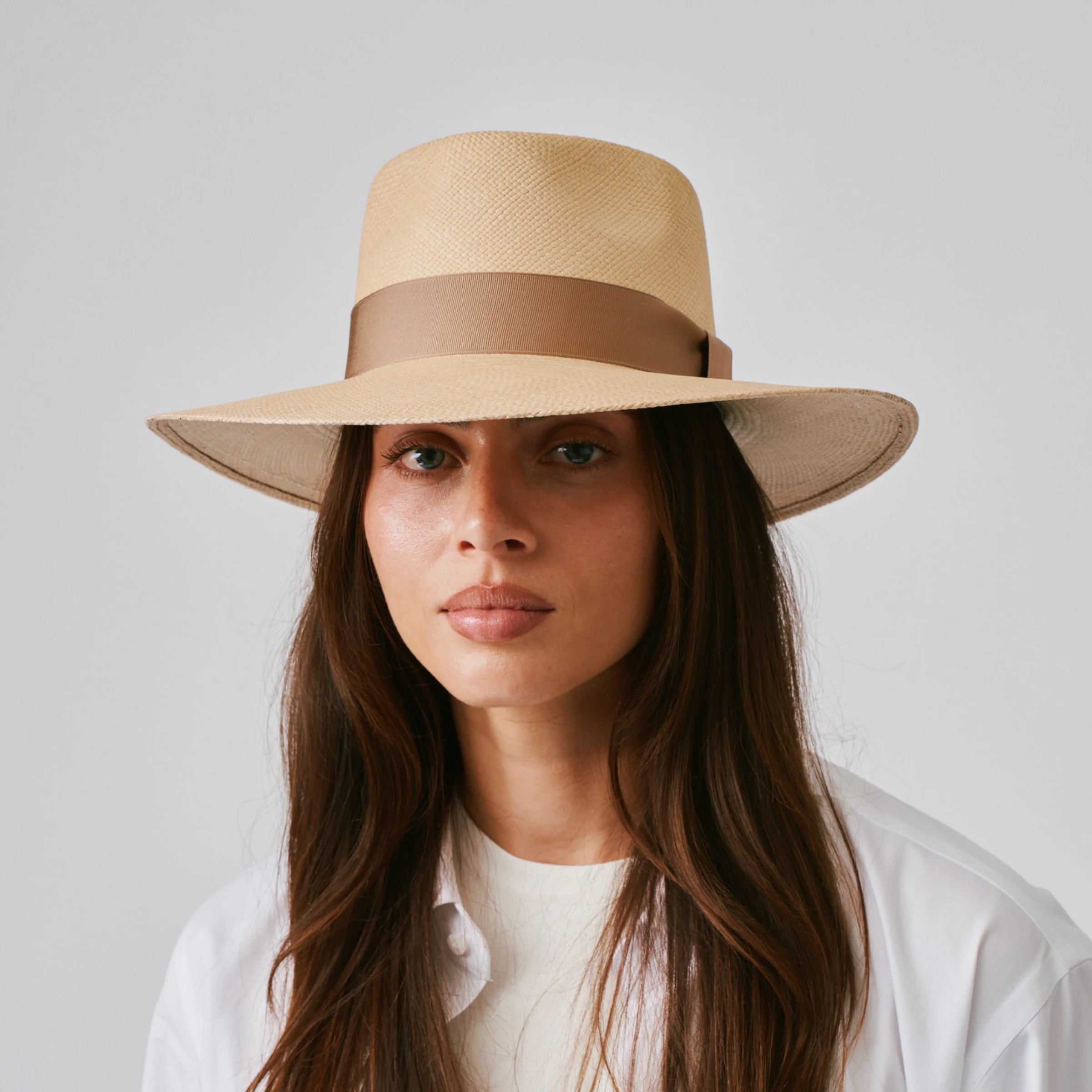 Woman wearing a Country Sand / Tan Panama hat and white shirt against a plain background.