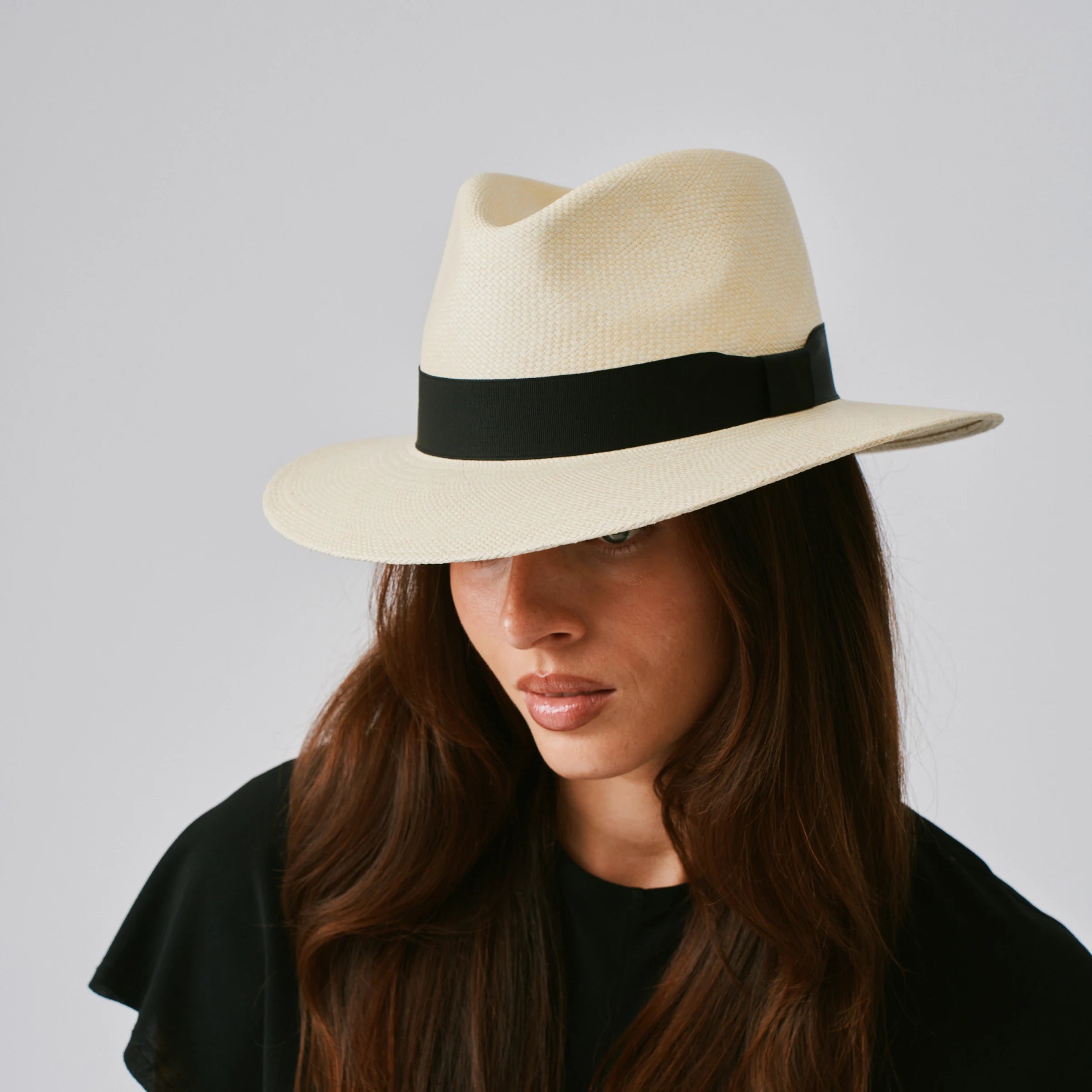 Woman wearing a Executive Natural / Black Panama hat against a plain background.