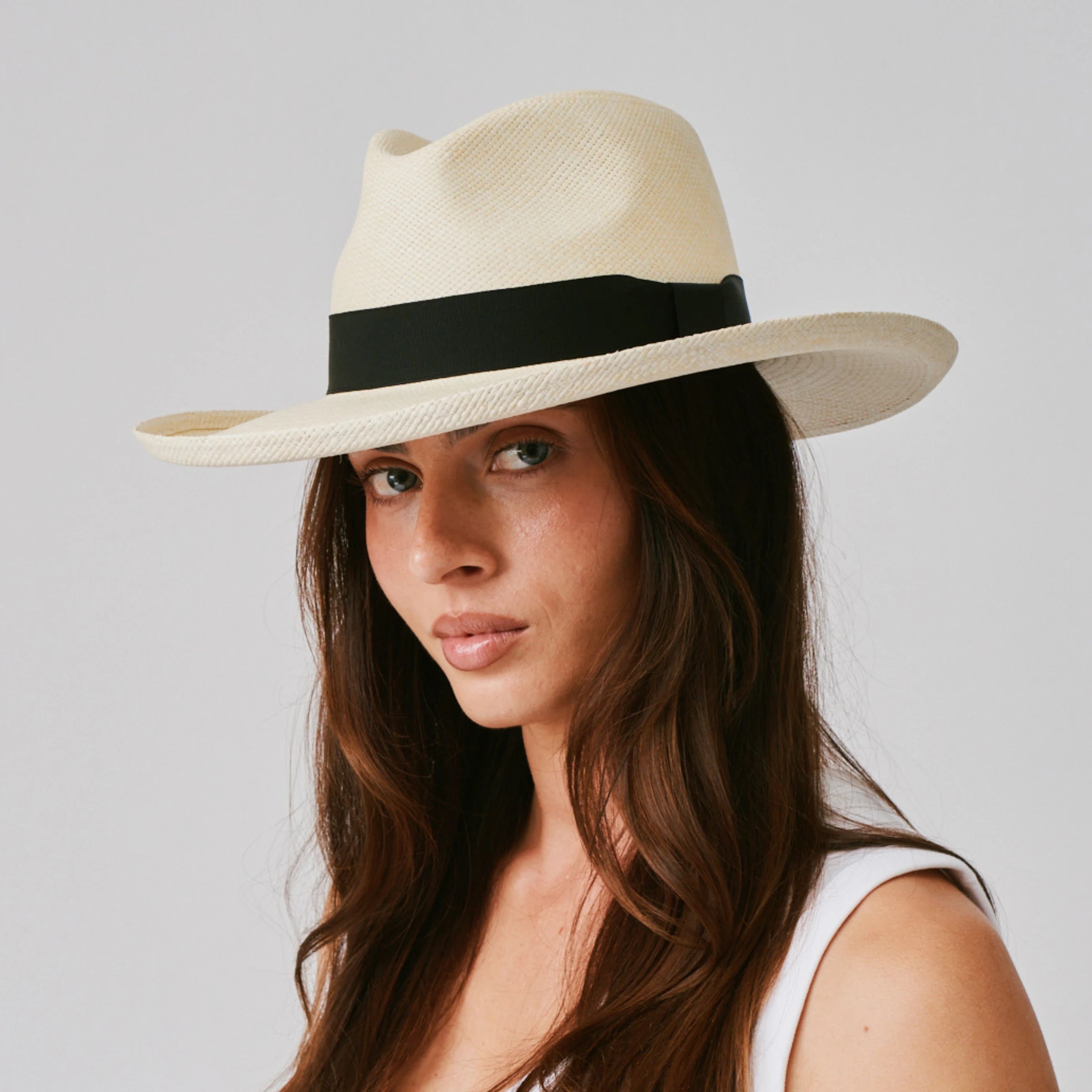 Woman wearing a Grand Planter Natural / Black Panama hat against a plain background.
