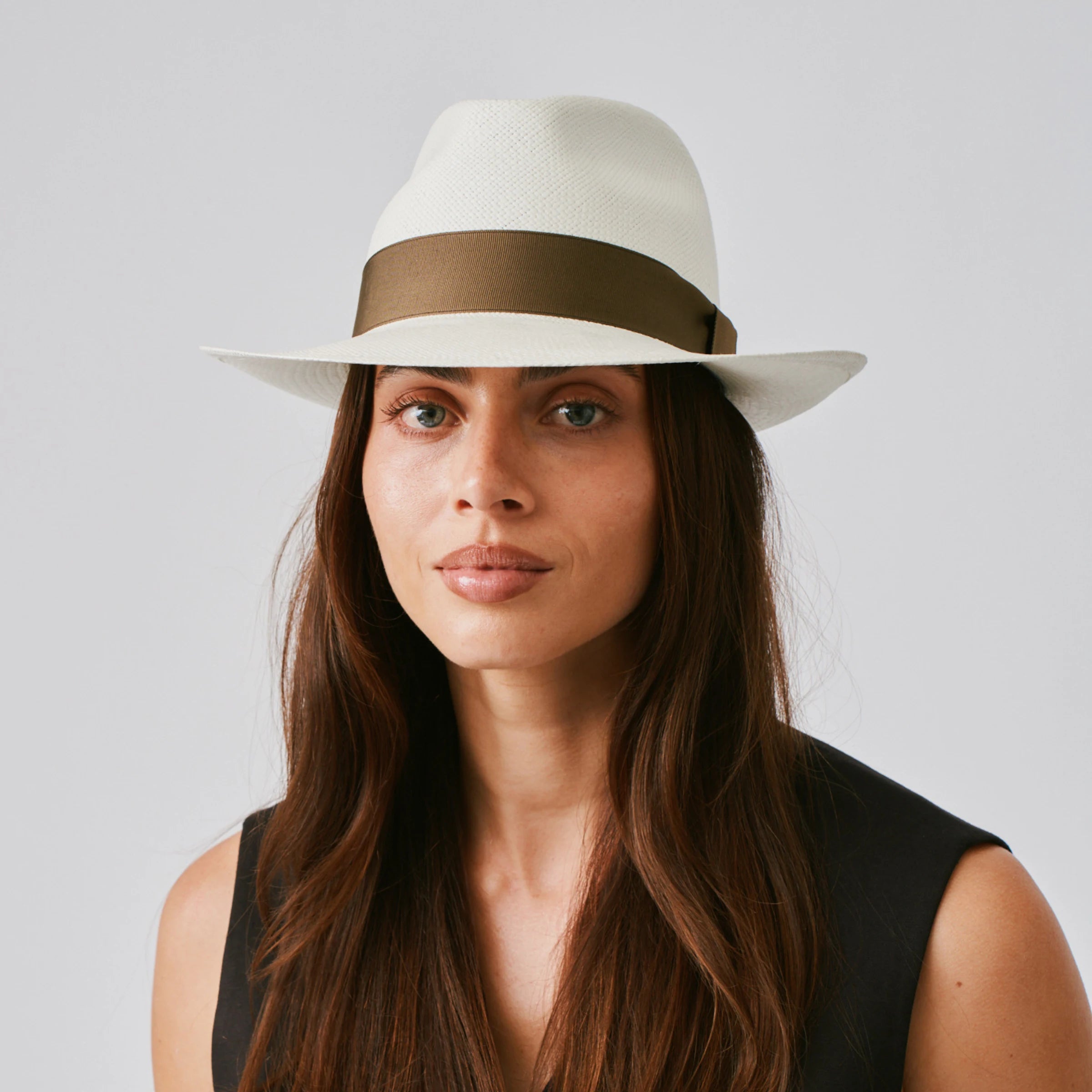 Woman wearing a New Fedora Cream / Fawn Panama hat and a black top against a plain background.