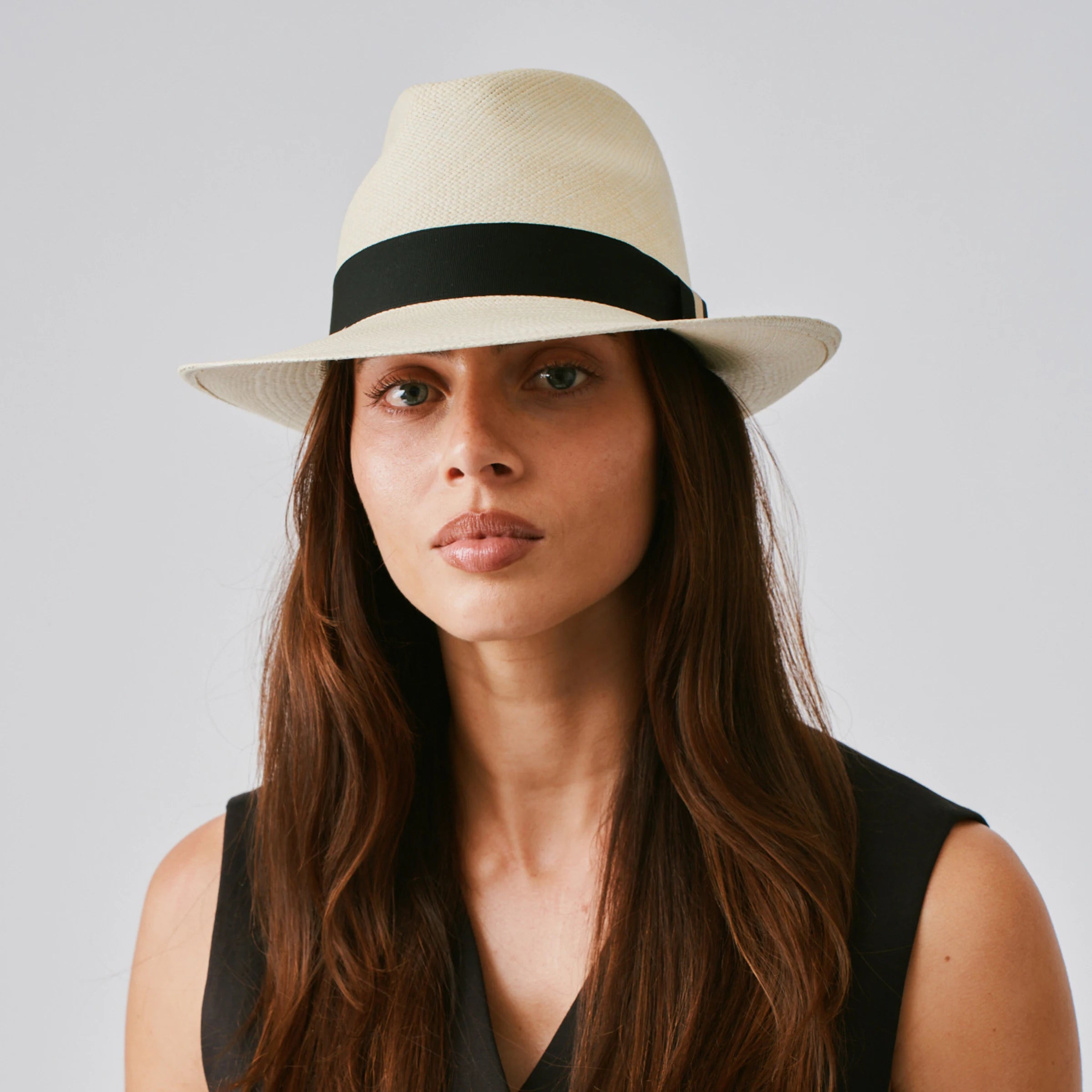 Woman wearing a New Fedora Natural / Black Panama hat and a black top against a plain background.