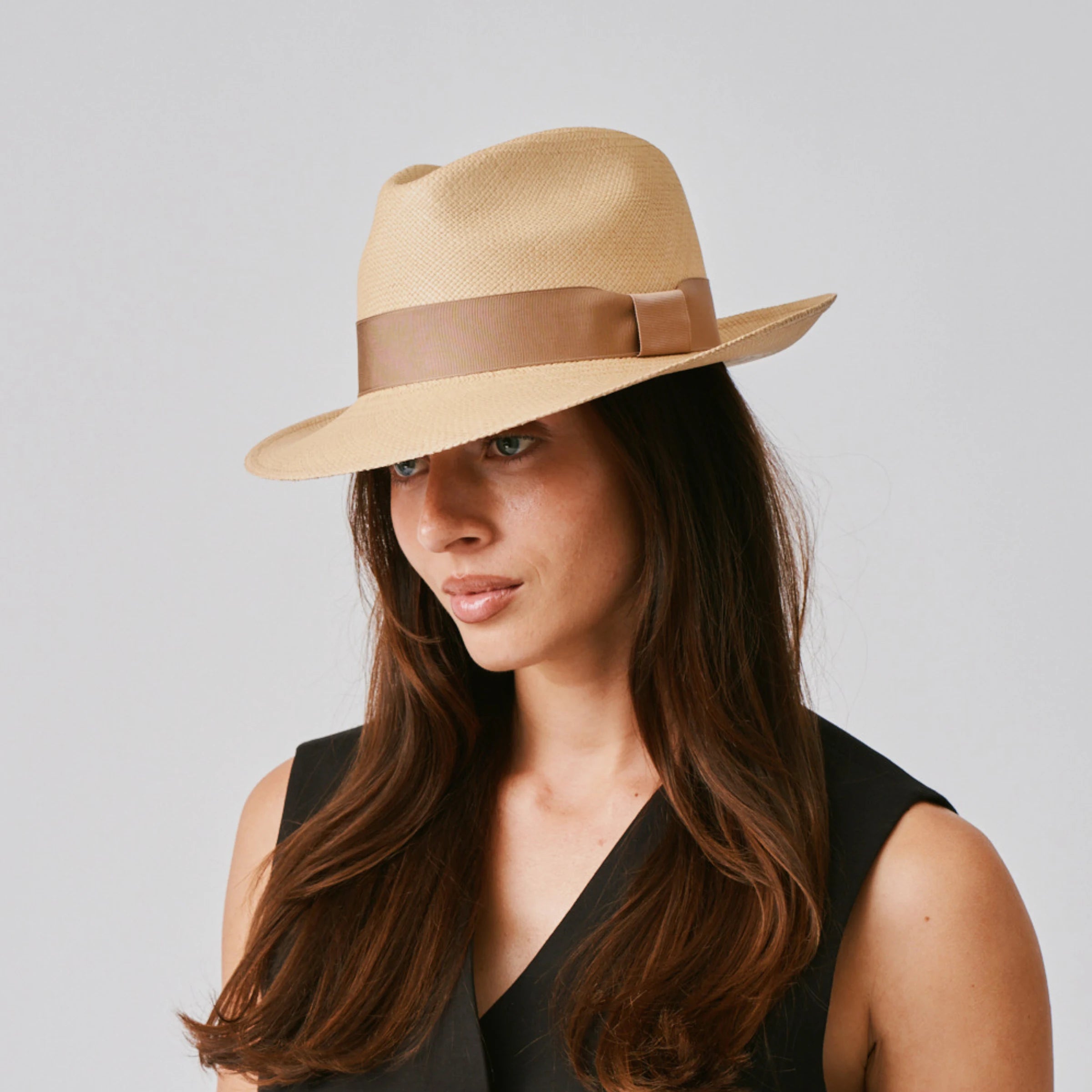 Woman wearing a New Fedora Sand / Tan Panama hat against a plain background.