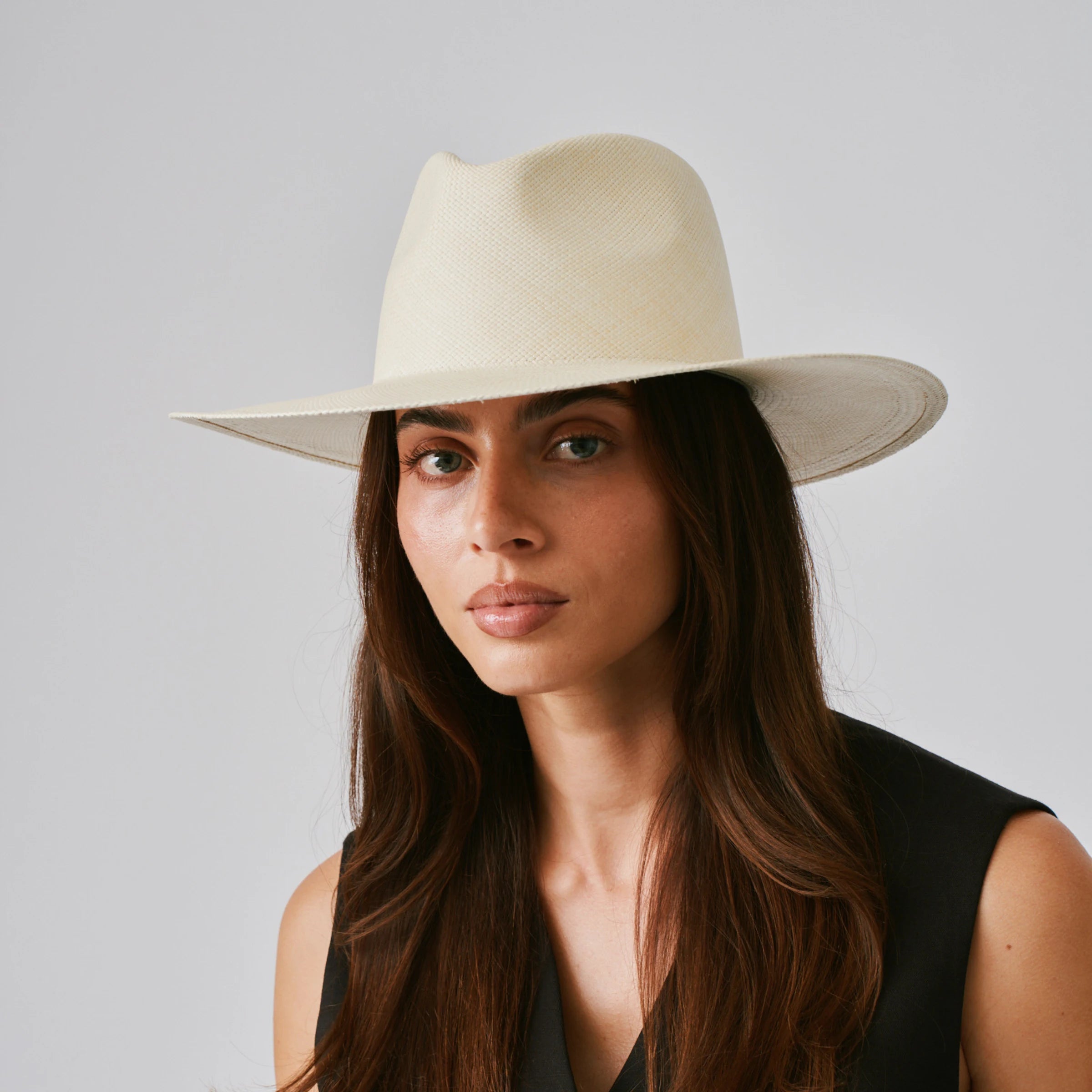 Woman wearing a Oro Natural Panama hat against a plain background.